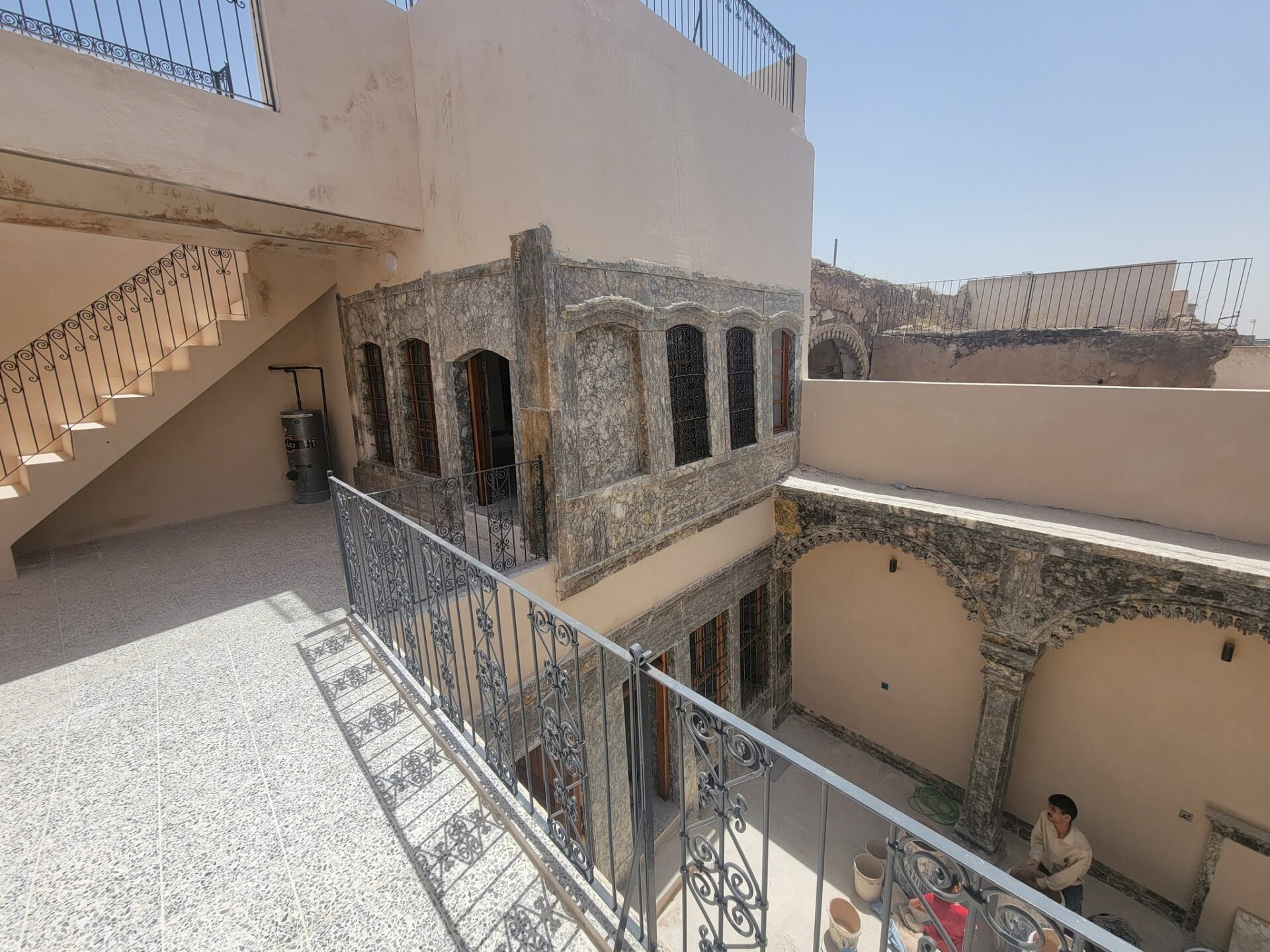 a balcony with a man sitting on a chair