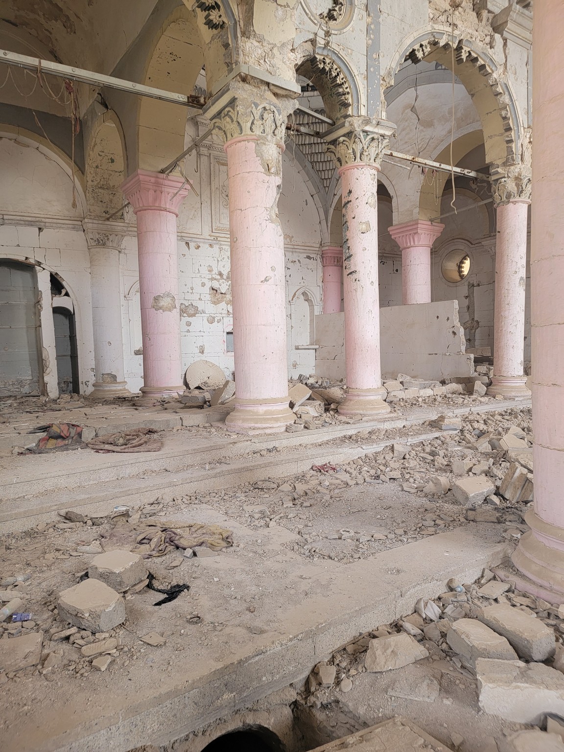 a ruined building with pink pillars