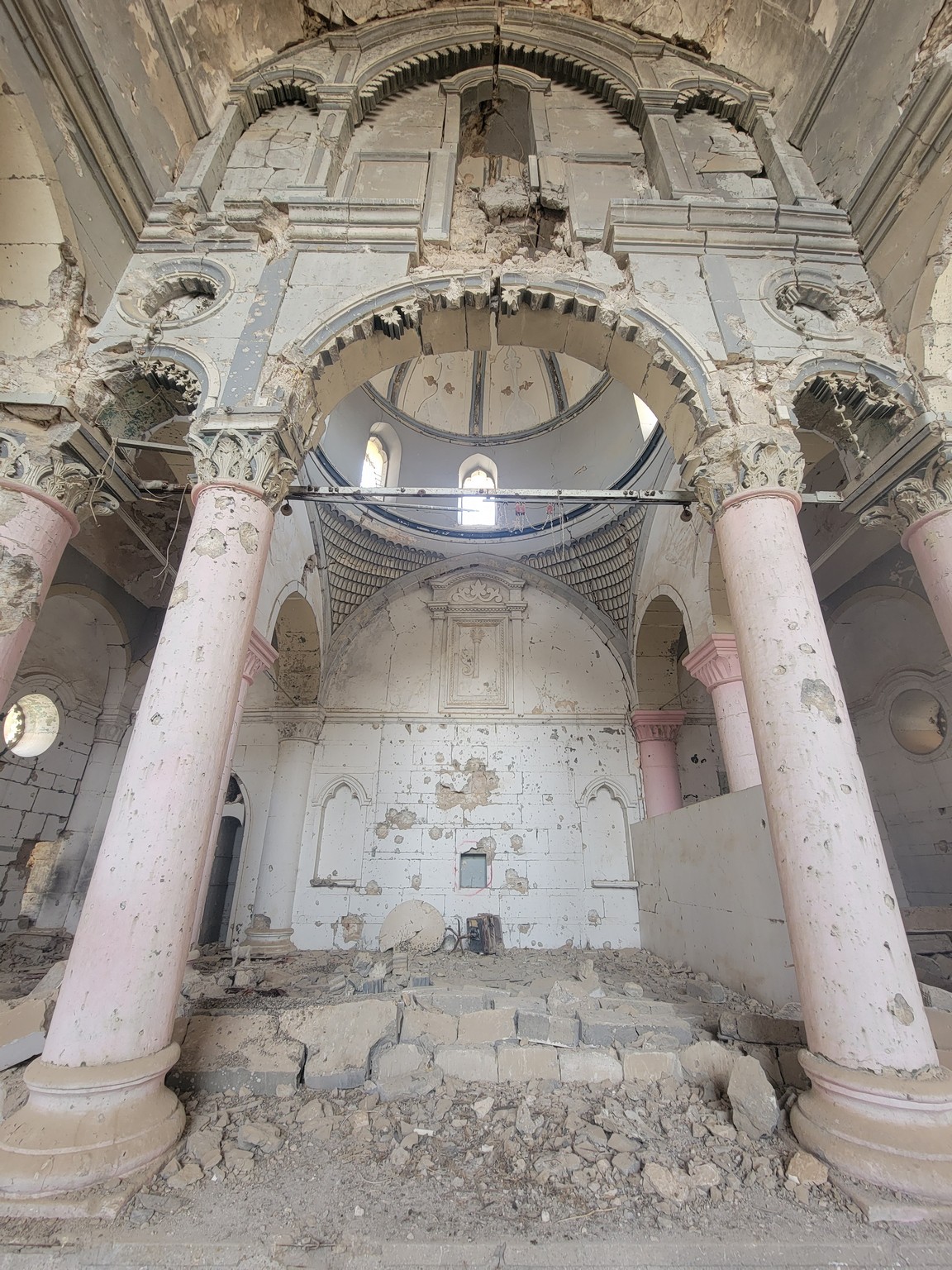 a ruined building with columns and arches