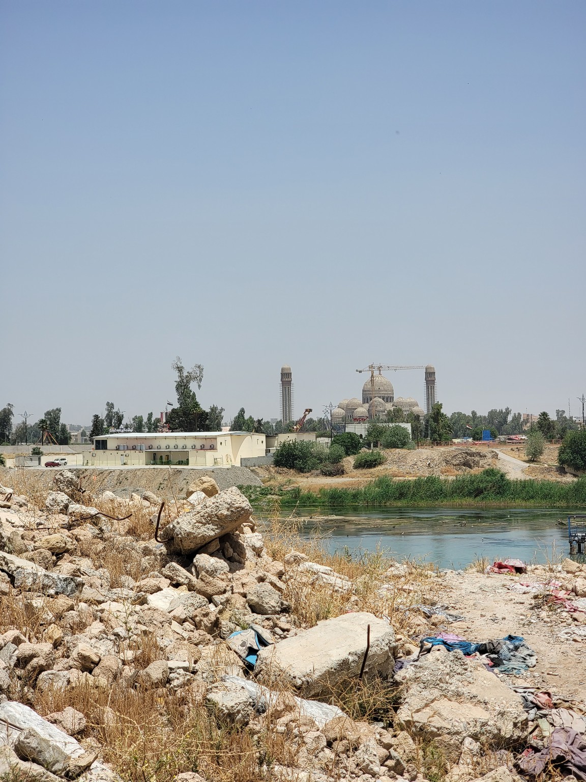 a rocky area with a body of water and a building in the background