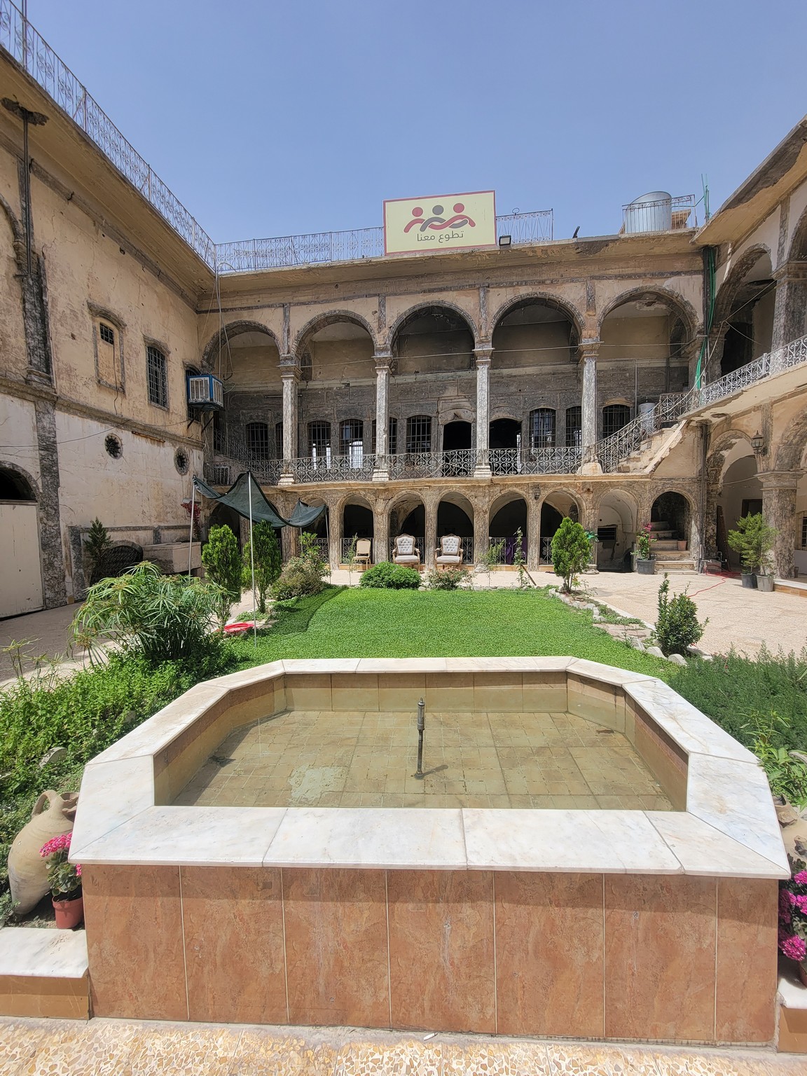 a courtyard with a fountain and a building with columns