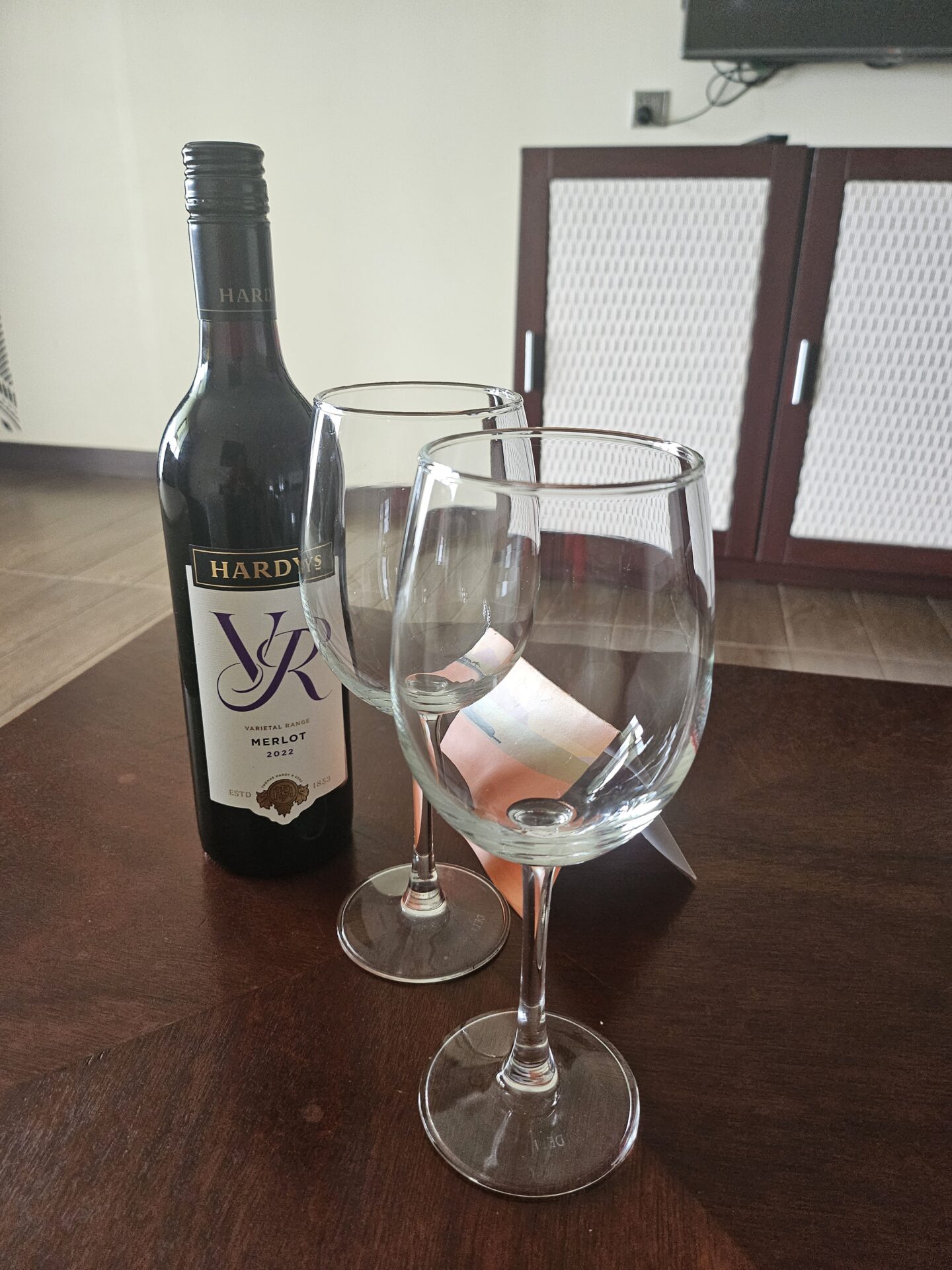 a bottle of wine next to two wine glasses