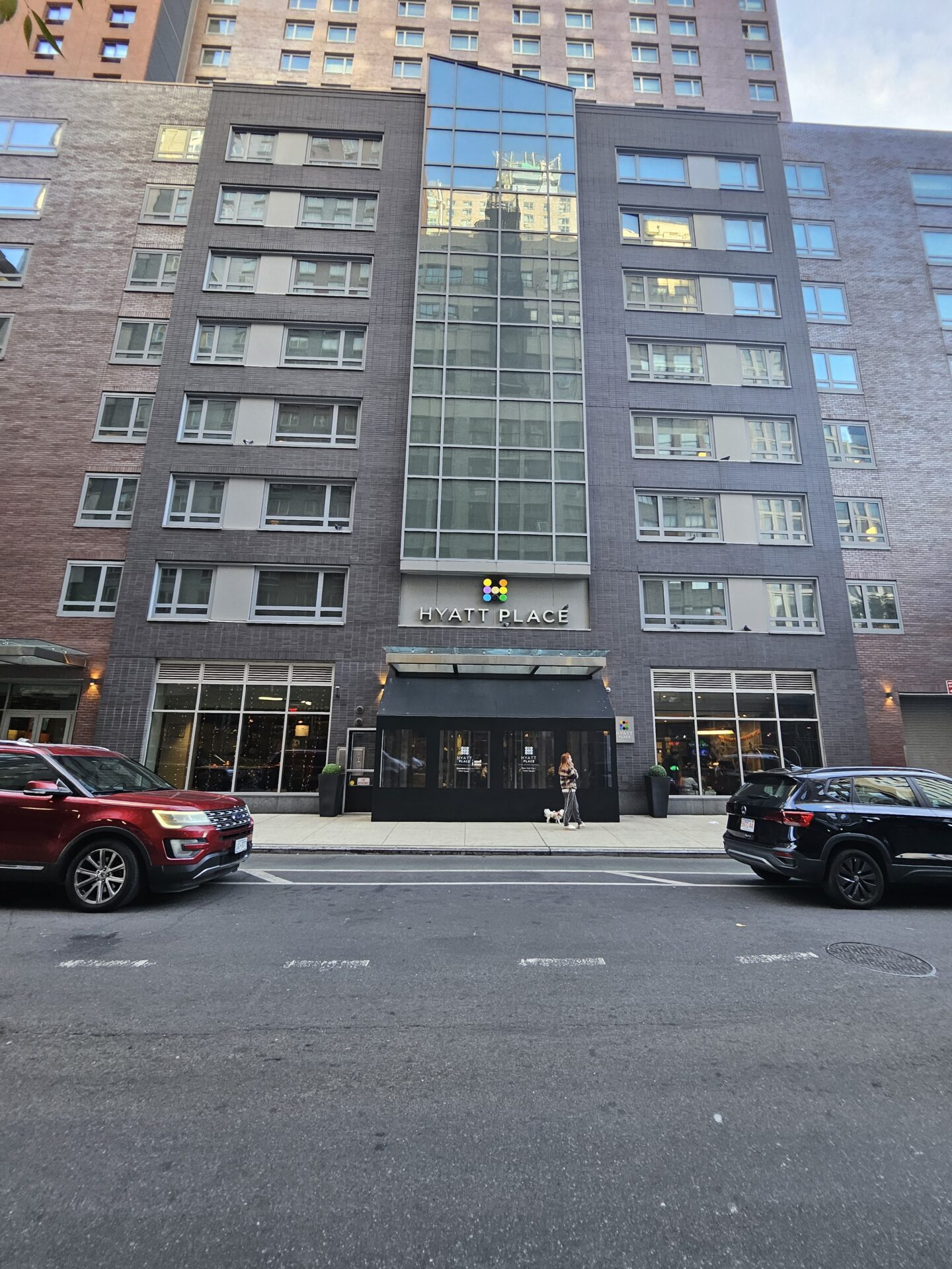 a building with windows and cars parked on the side of the road