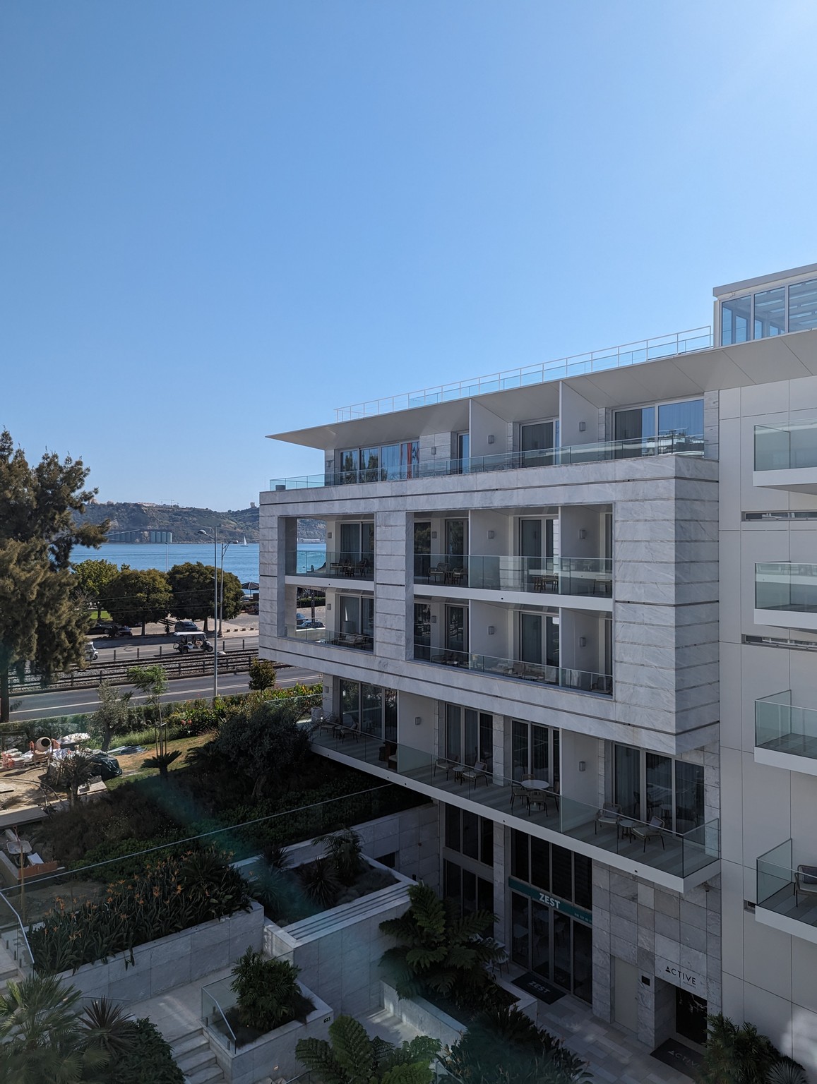 a building with balconies and trees and water in the background