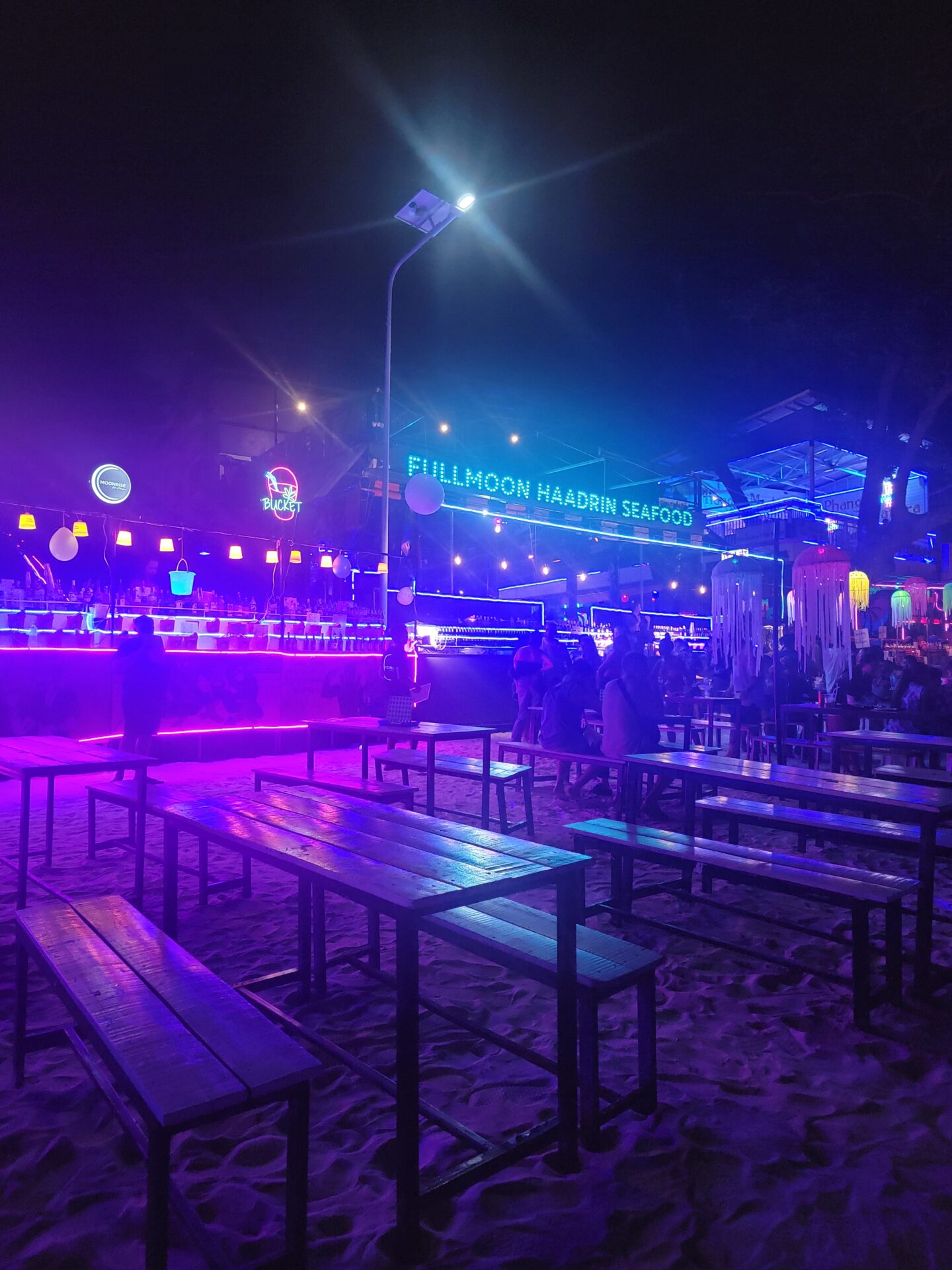 a group of benches and tables in a beach area