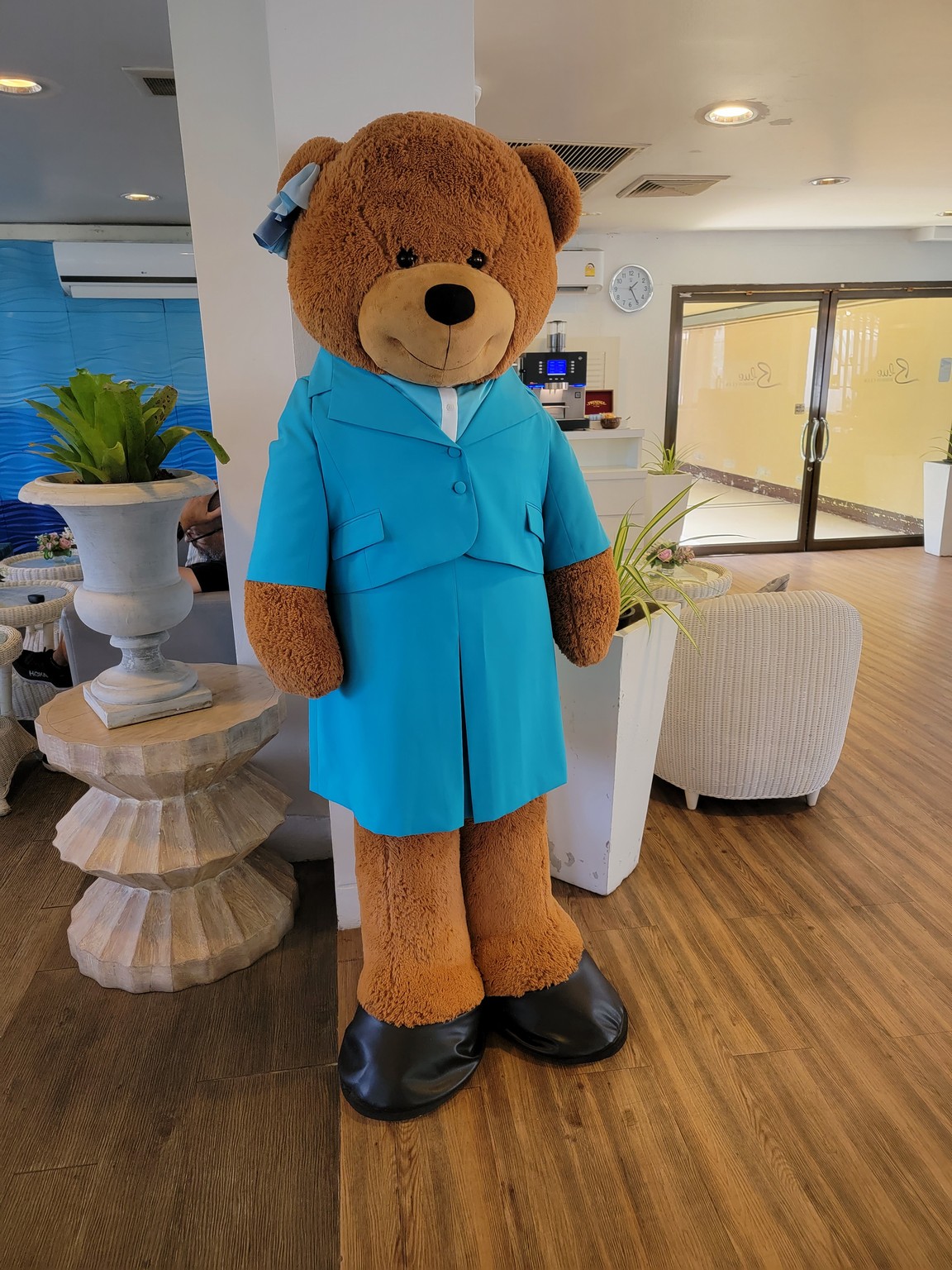 a large teddy bear wearing a blue suit