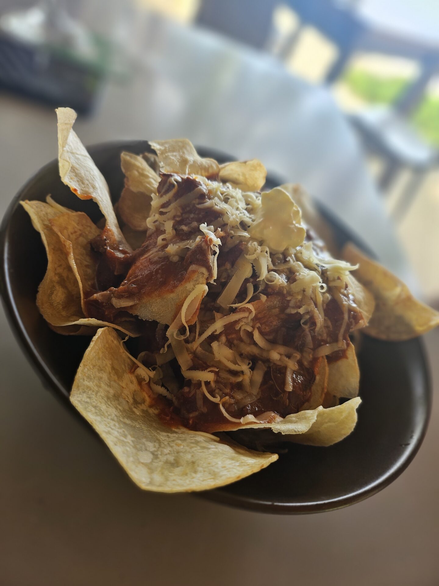 a bowl of chips with chili and cheese