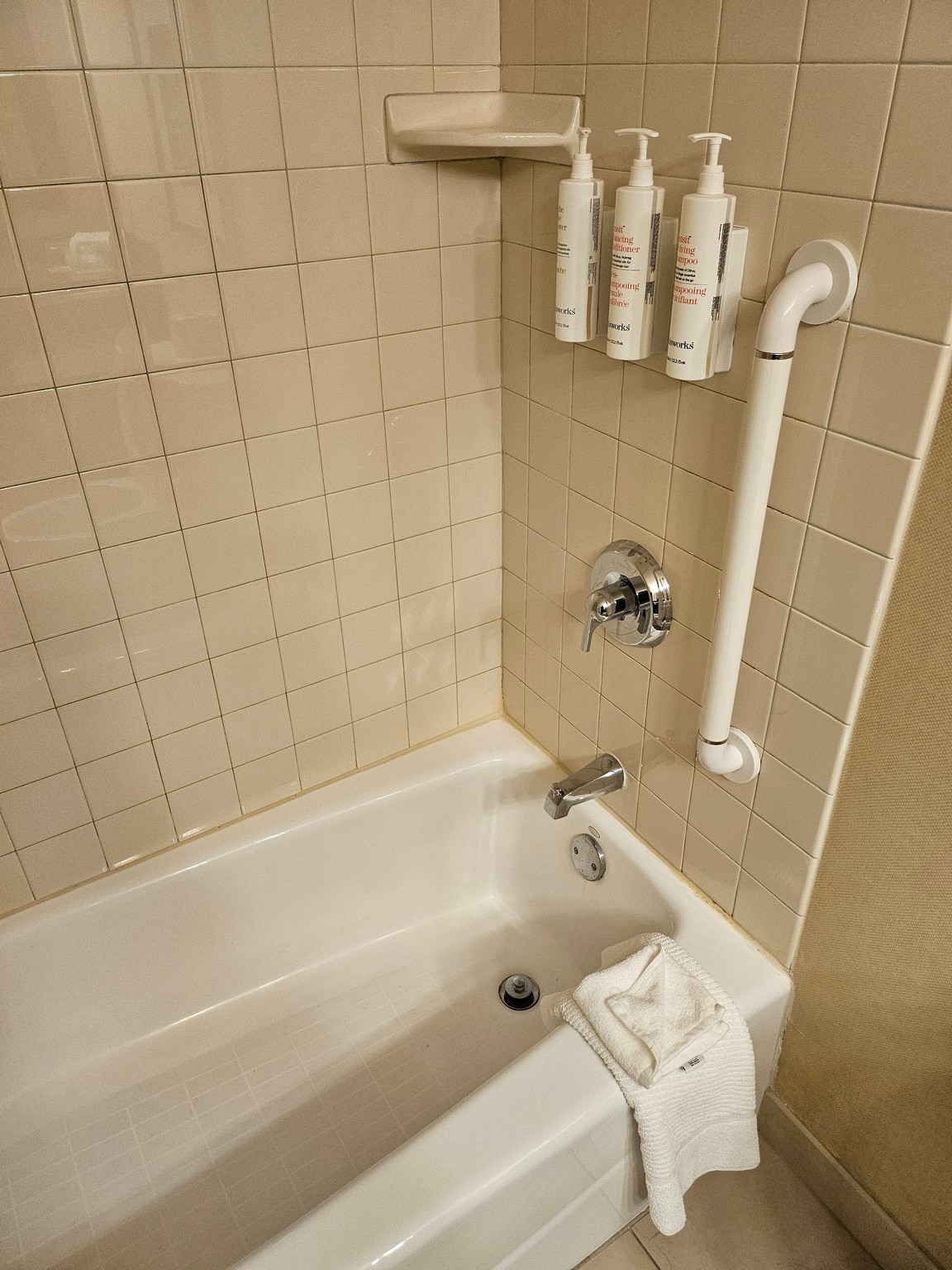 a bathtub with white towels and a towel rack