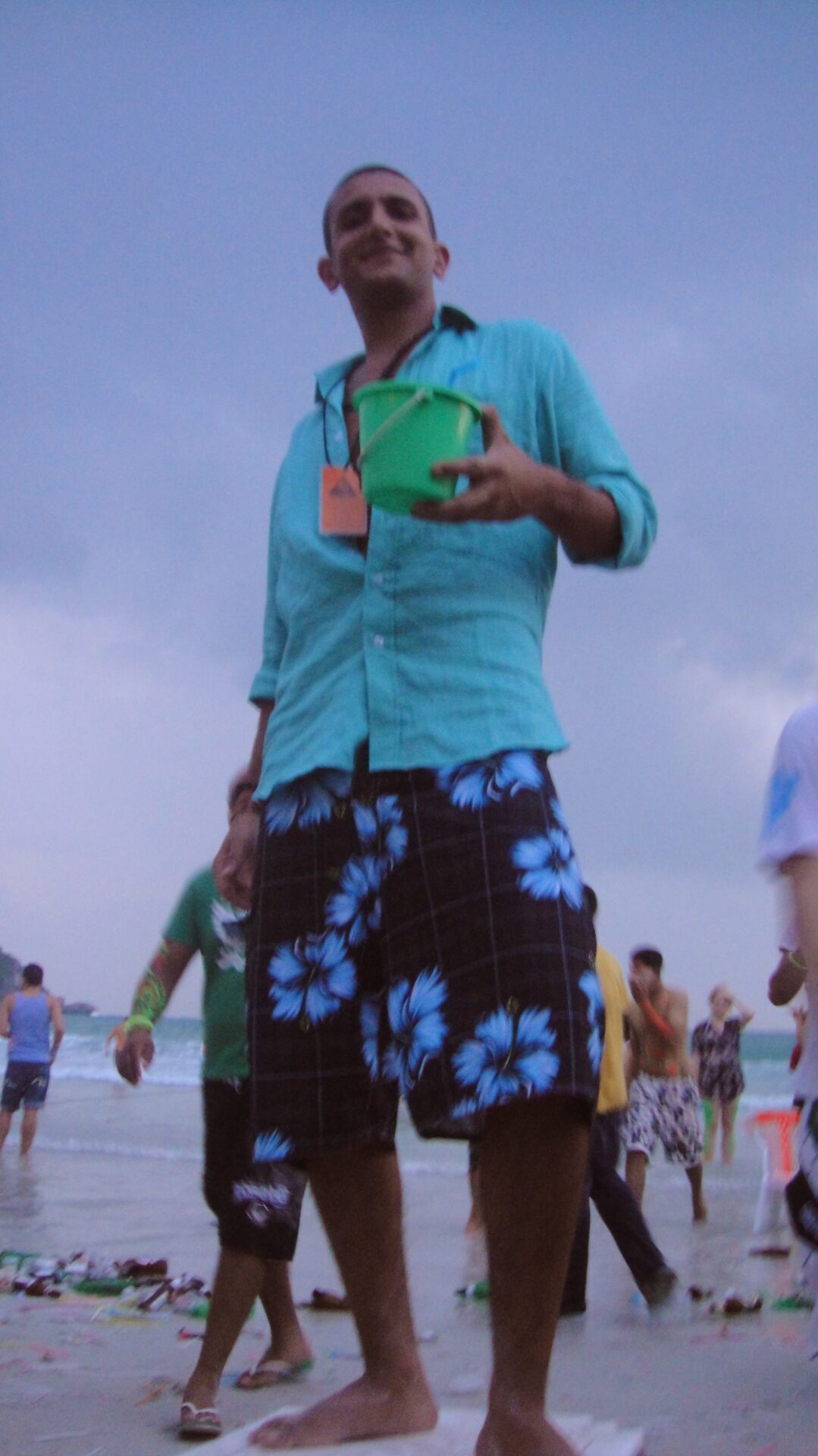 a man holding a bucket on a beach