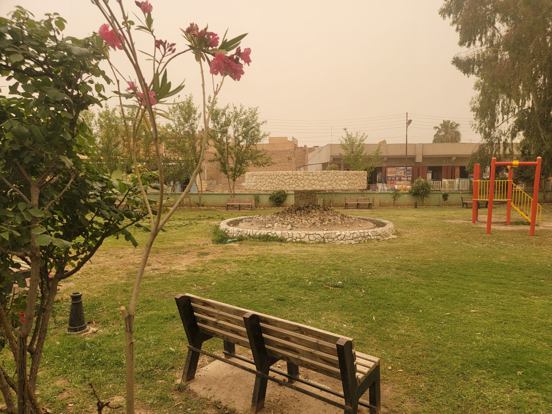 a park with a bench and a playground