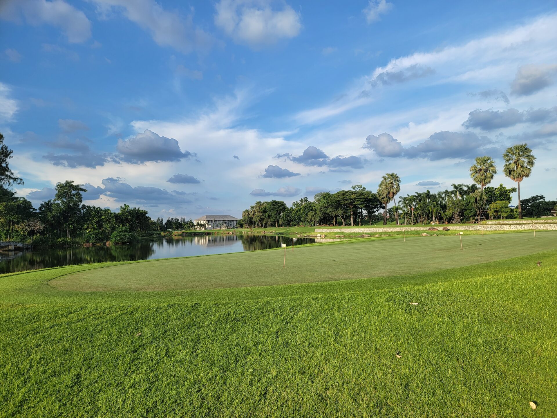 a golf course with a lake and trees