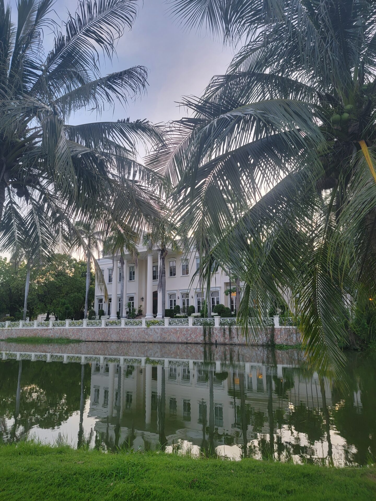 a building with palm trees and a body of water