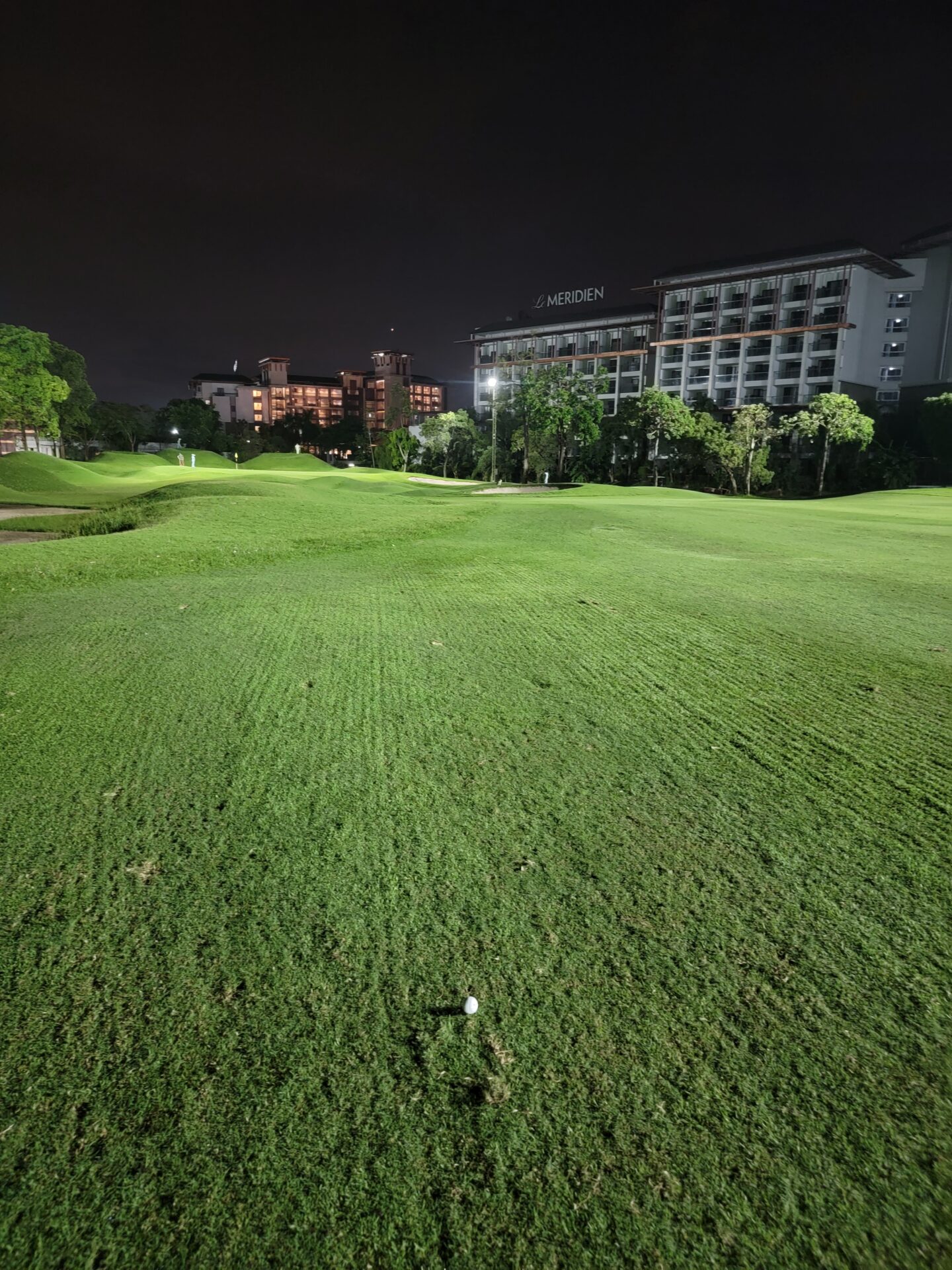 a large grassy area with a building in the background