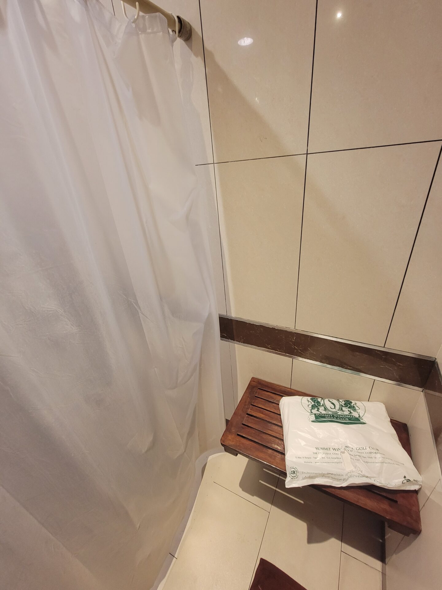 a white plastic bag on a wooden shelf in a shower