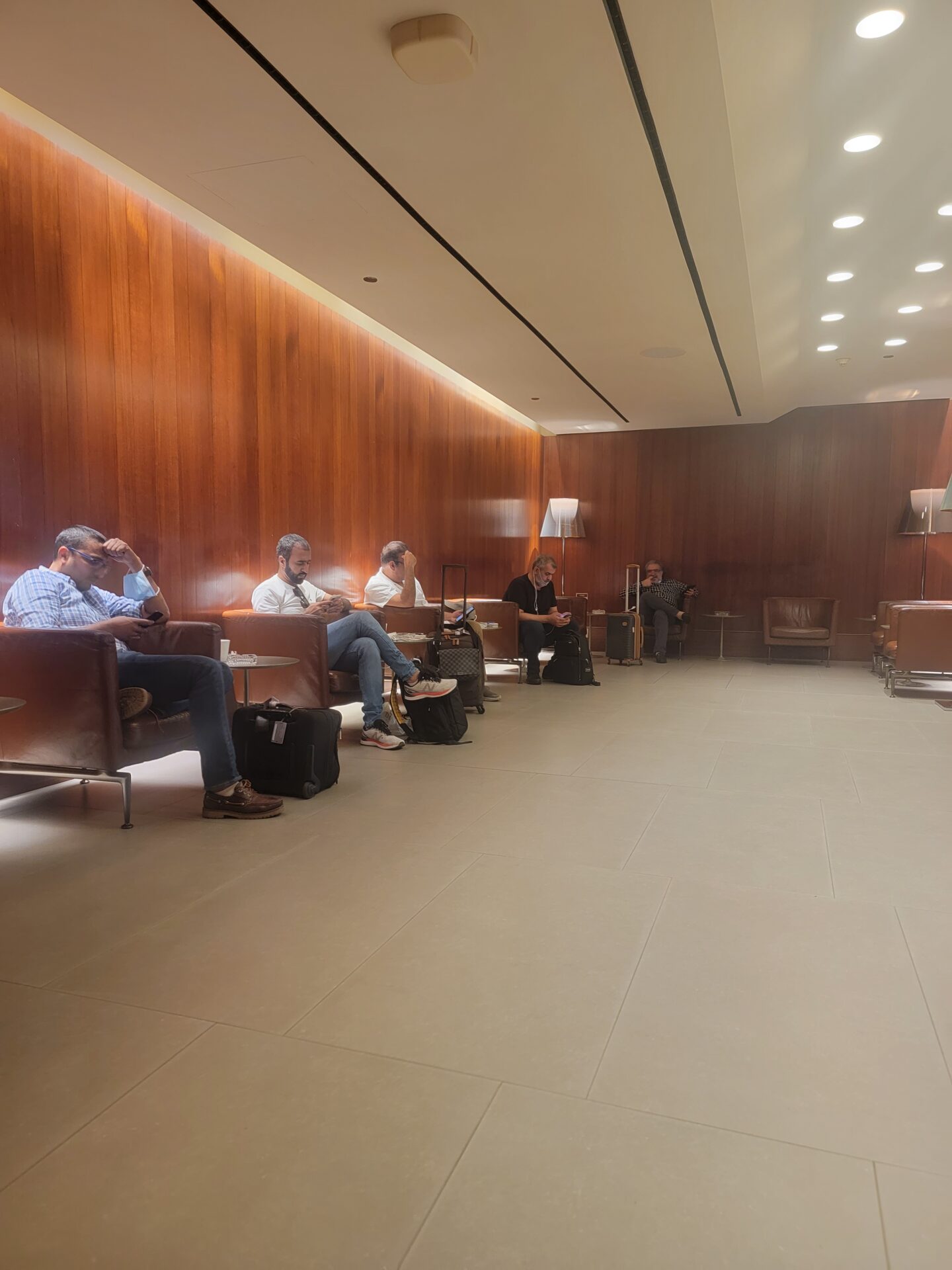 a group of people sitting in chairs in a room with wood walls