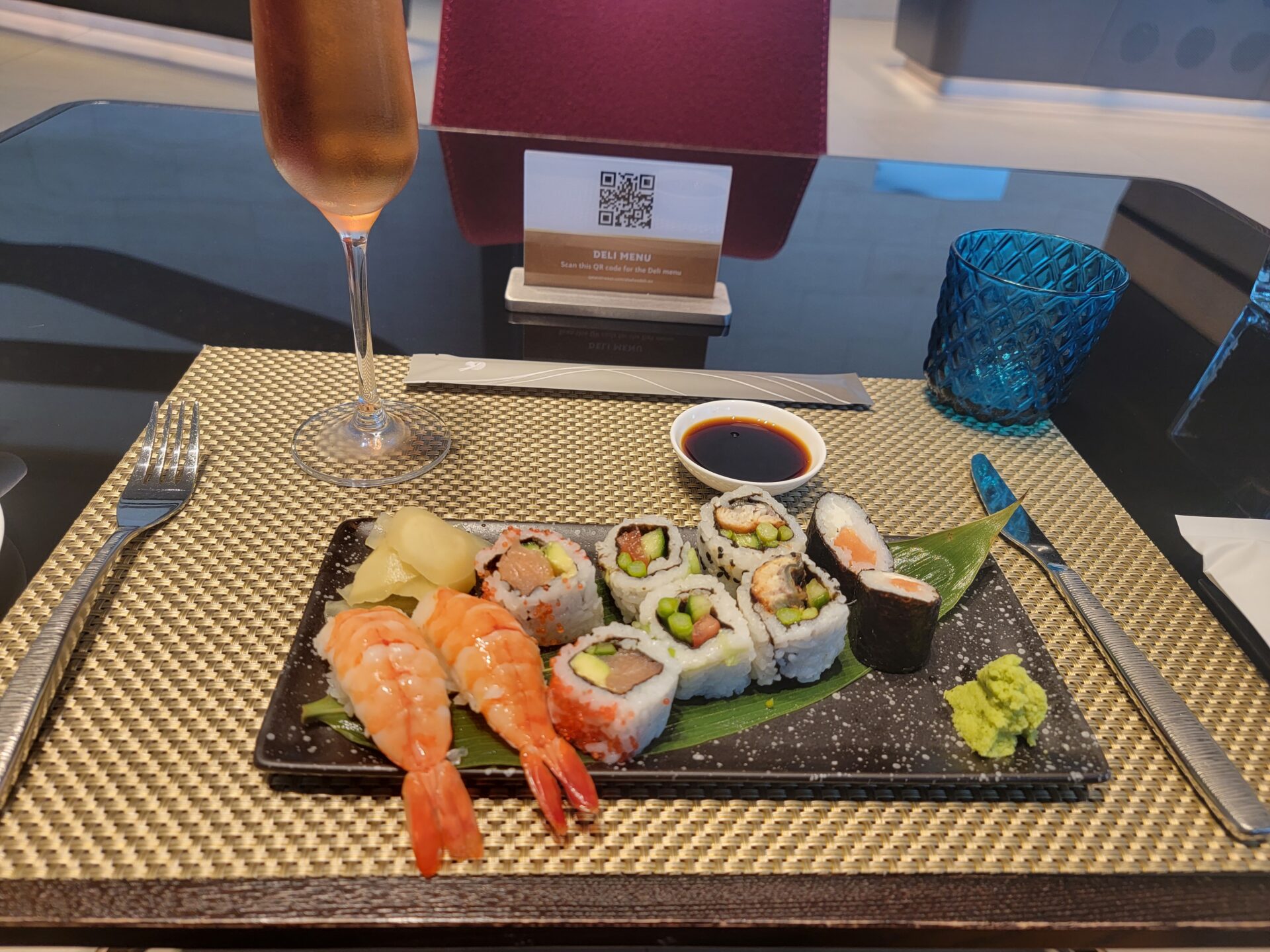 a plate of sushi and a glass of wine