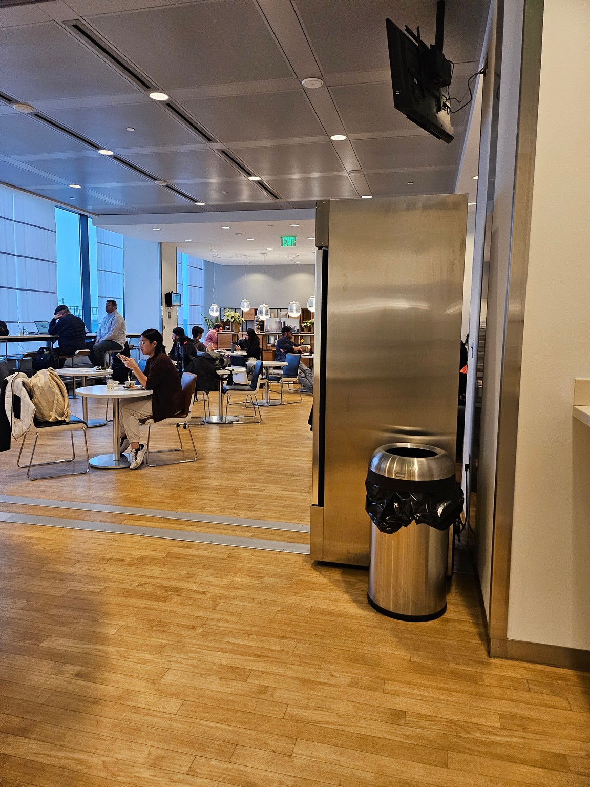 a group of people sitting at tables in a room with a metal door