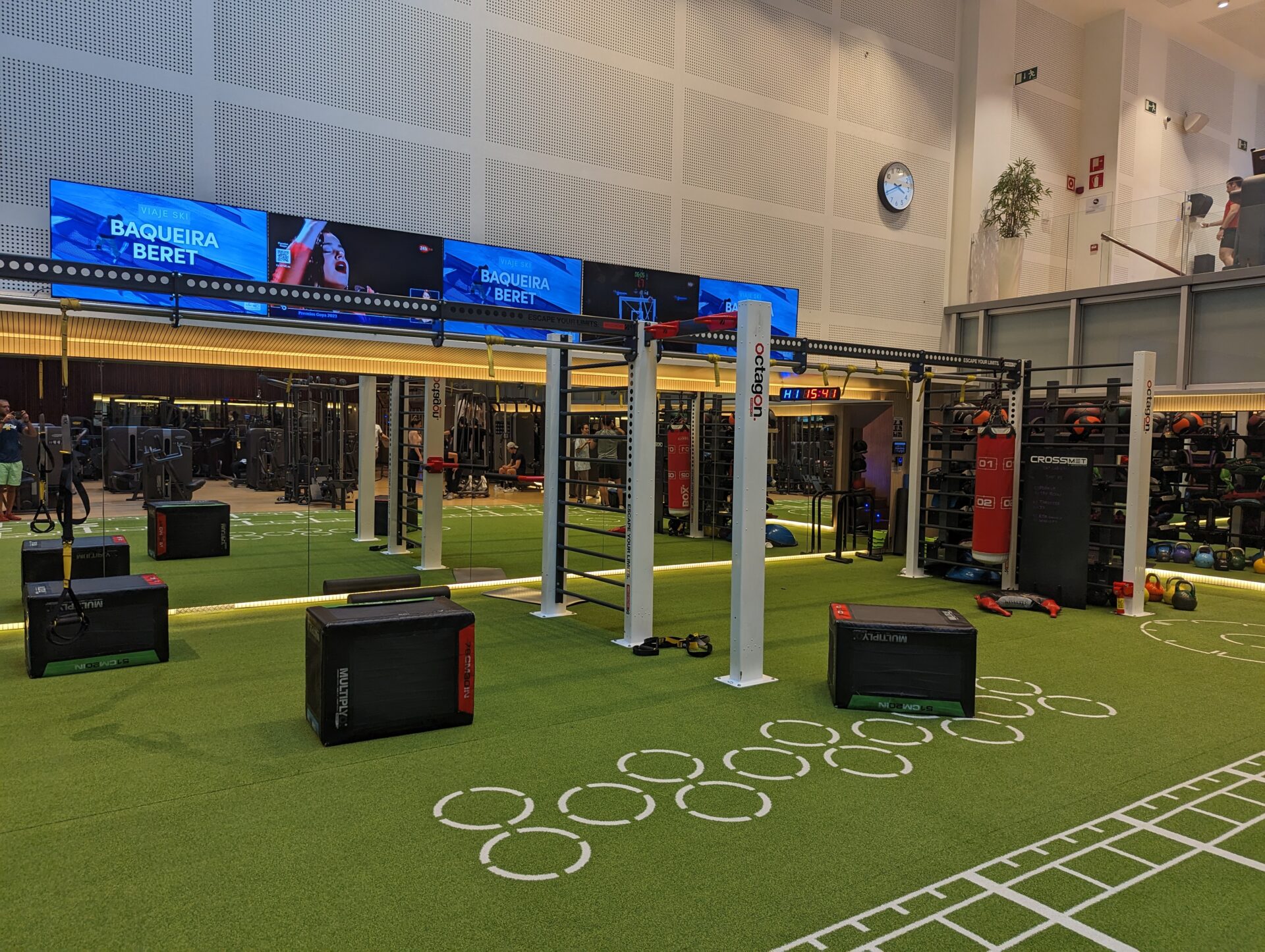 a gym with a green carpet and a large screen