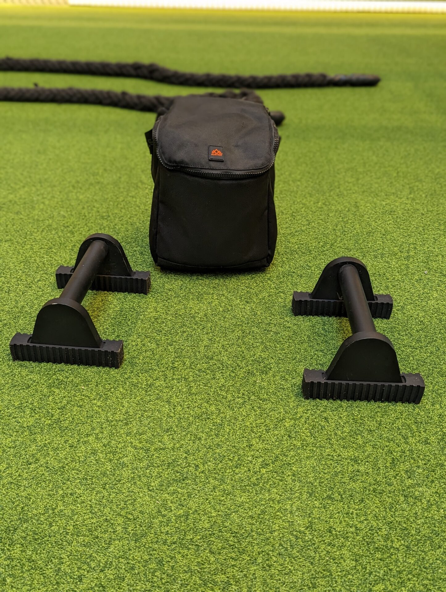 a black bag and weights on a green surface