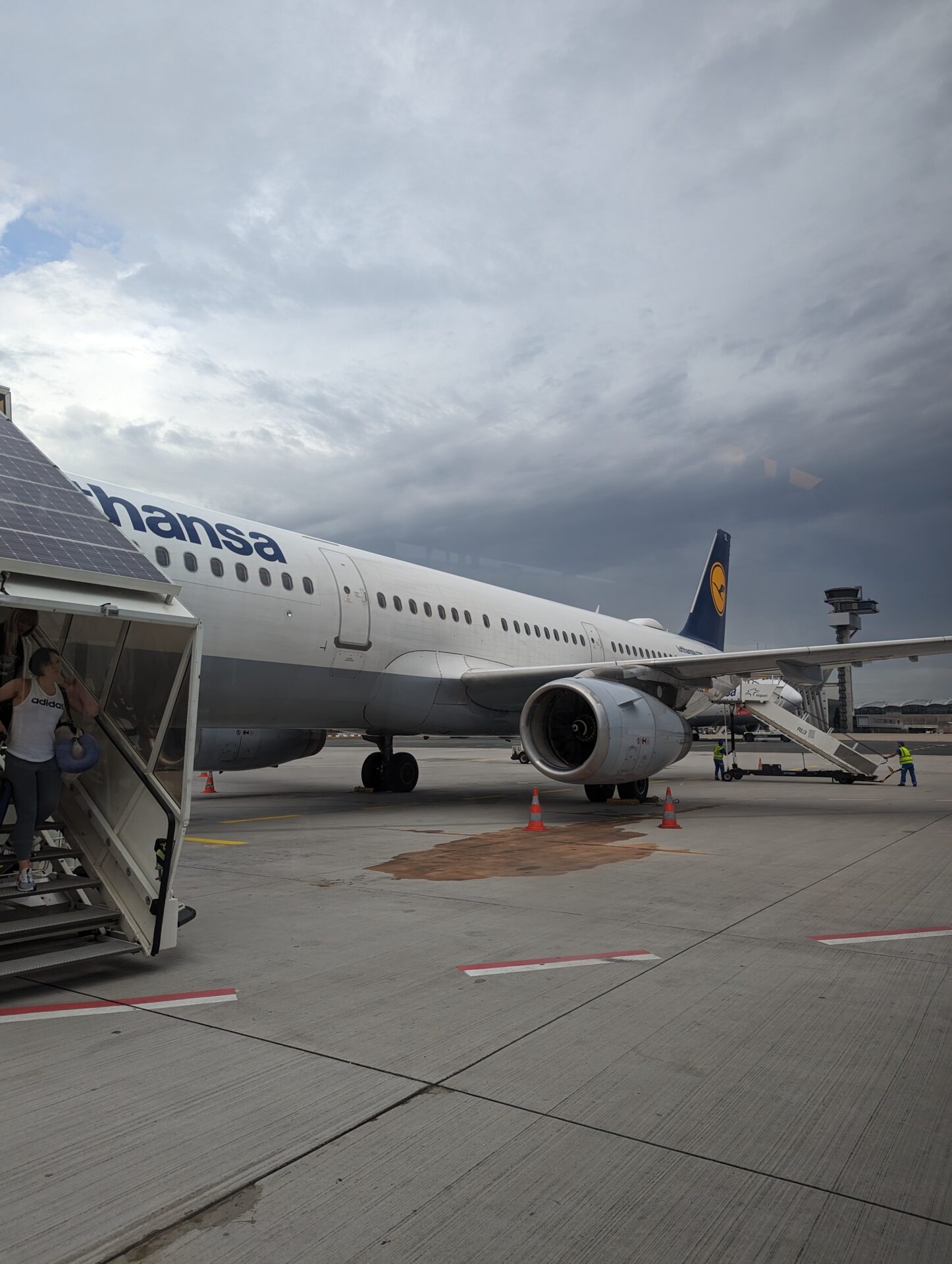 a plane with a staircase and people walking down it