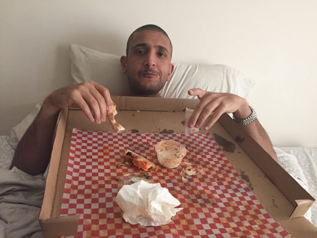 a man in a box eating pizza