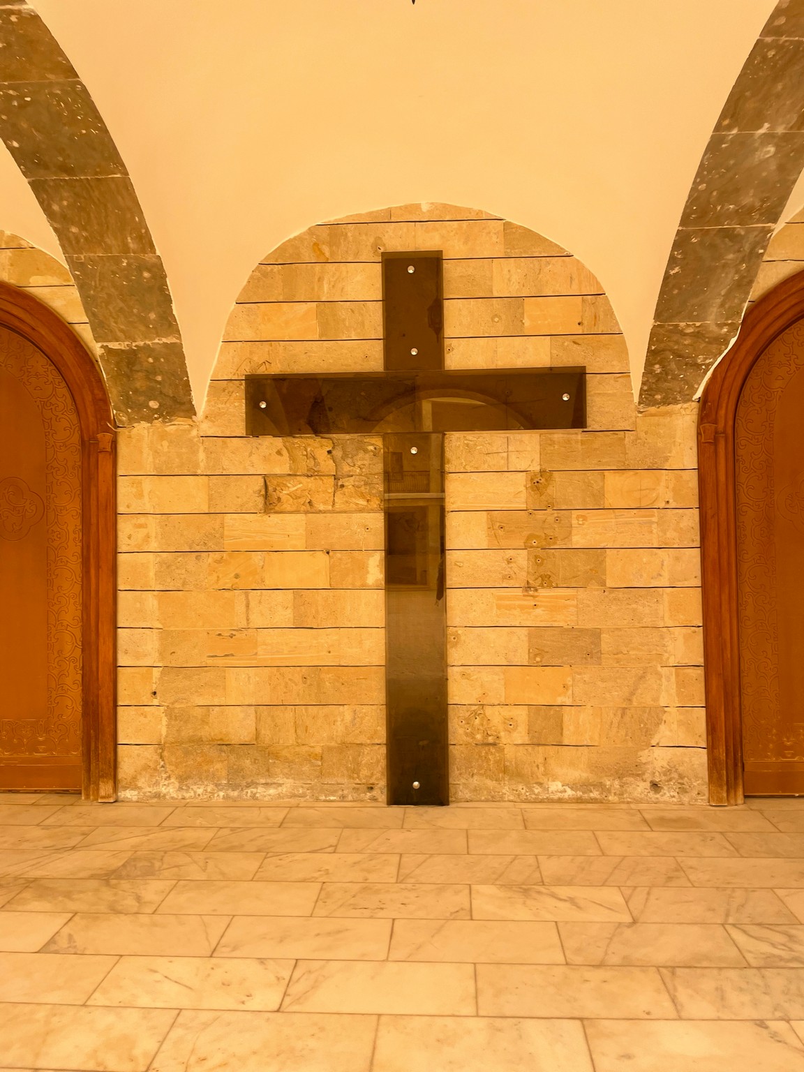 a cross on a brick wall