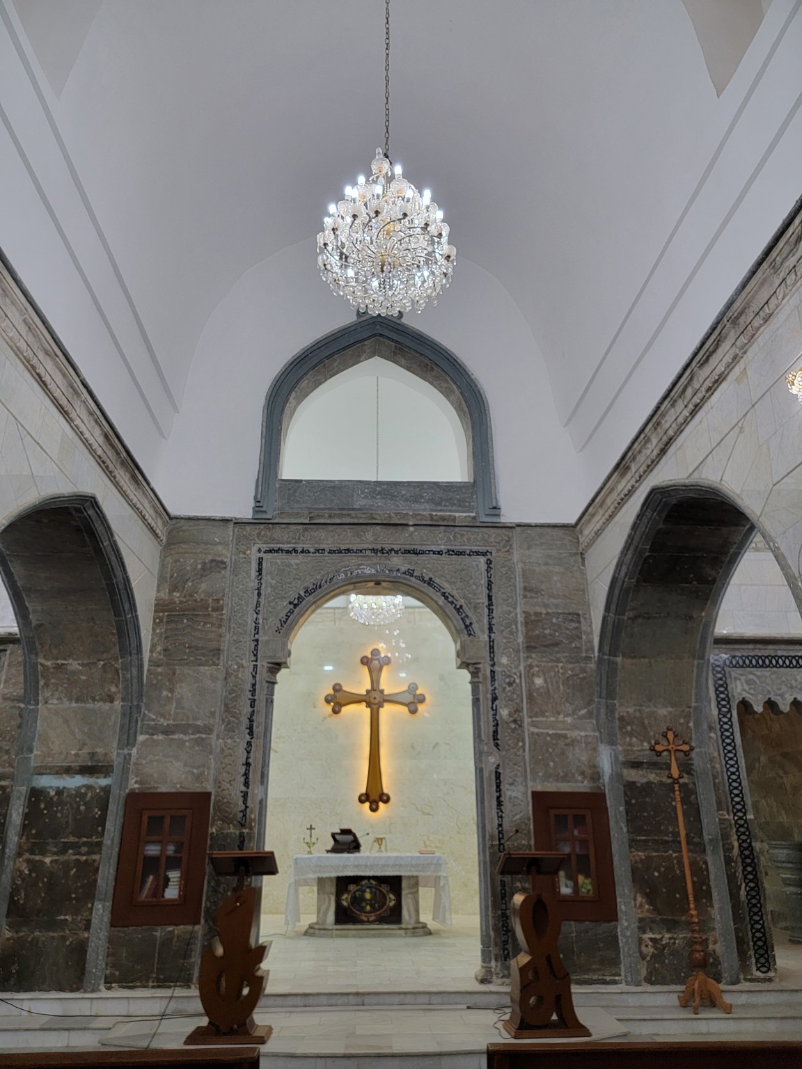 a room with a cross and a chandelier