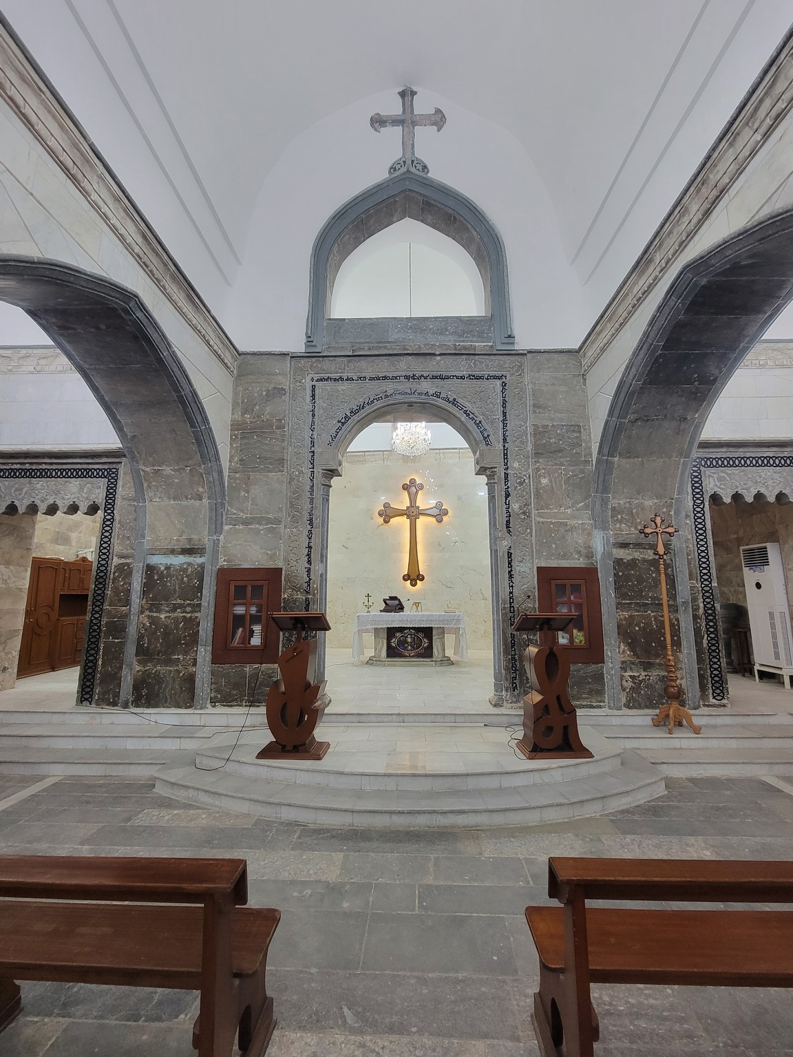 a stone building with a cross in the middle