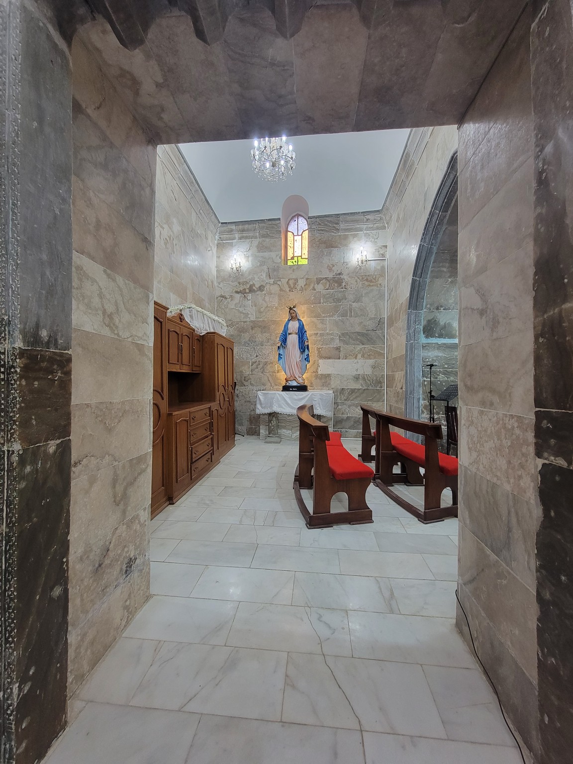 a stone room with a statue of a woman in a blue robe