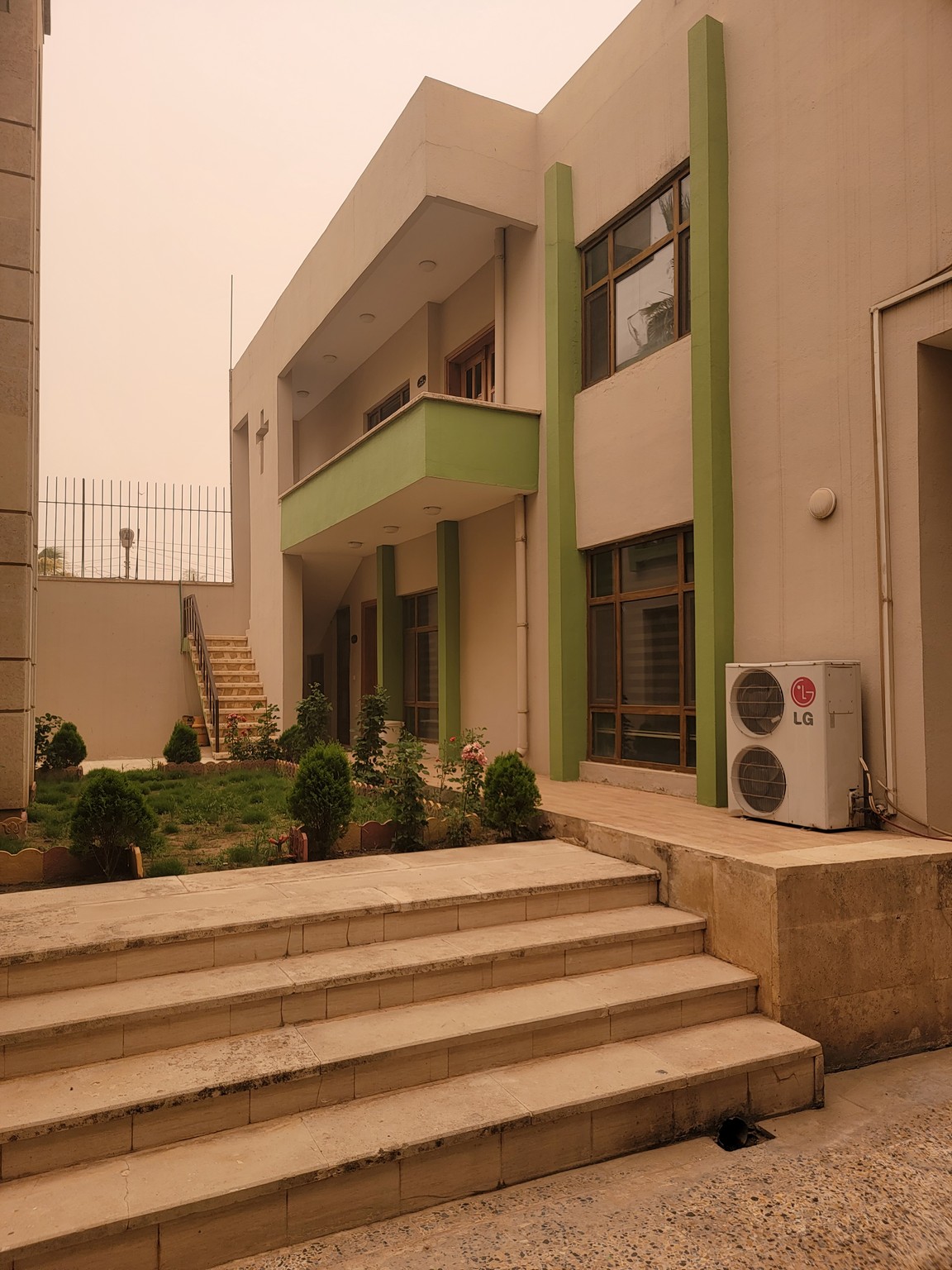 a building with stairs and a lawn