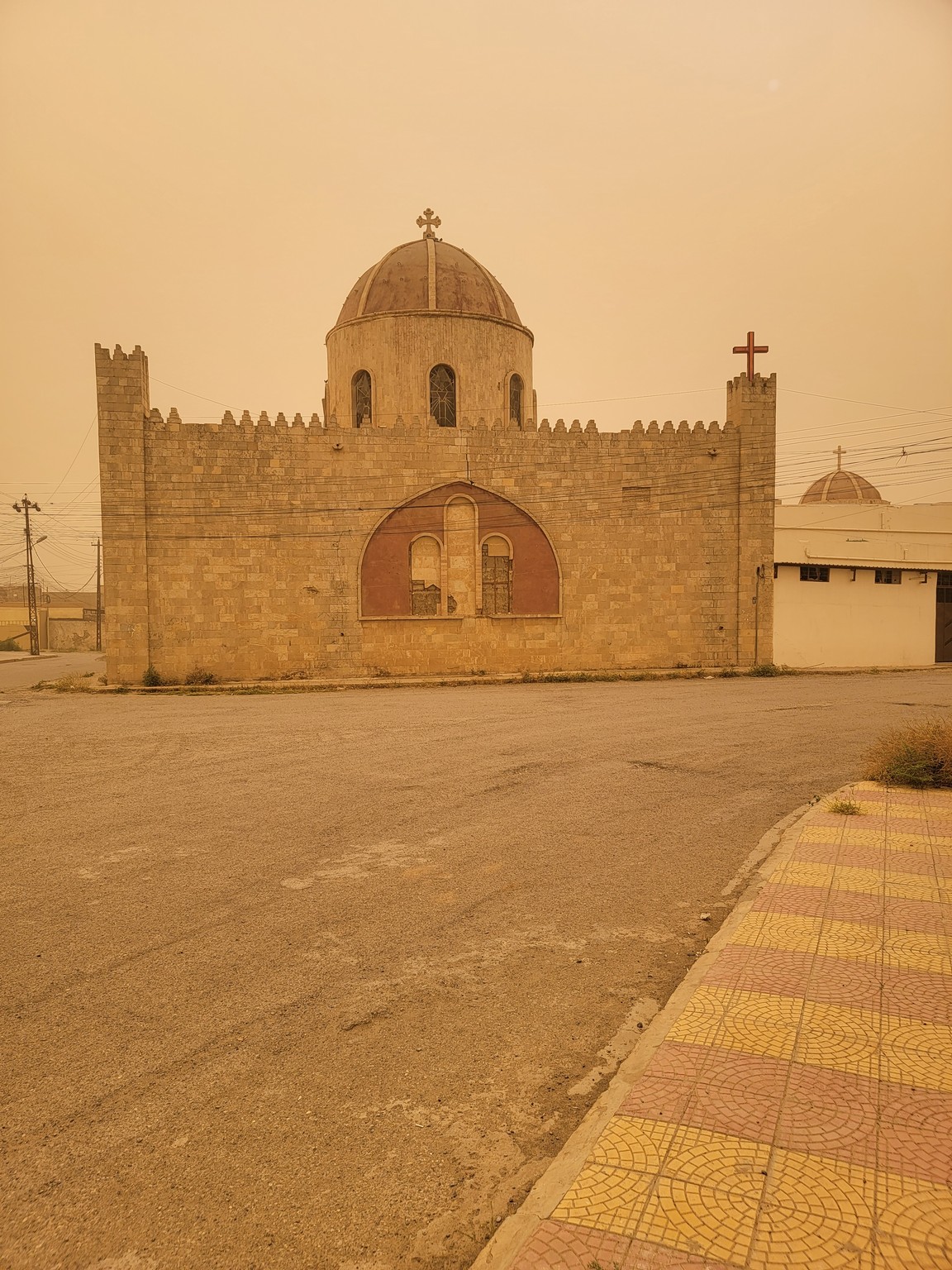 a stone building with a dome and a cross on the side