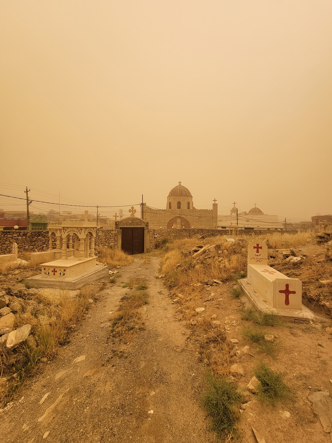 a dirt road leading to a cemetery