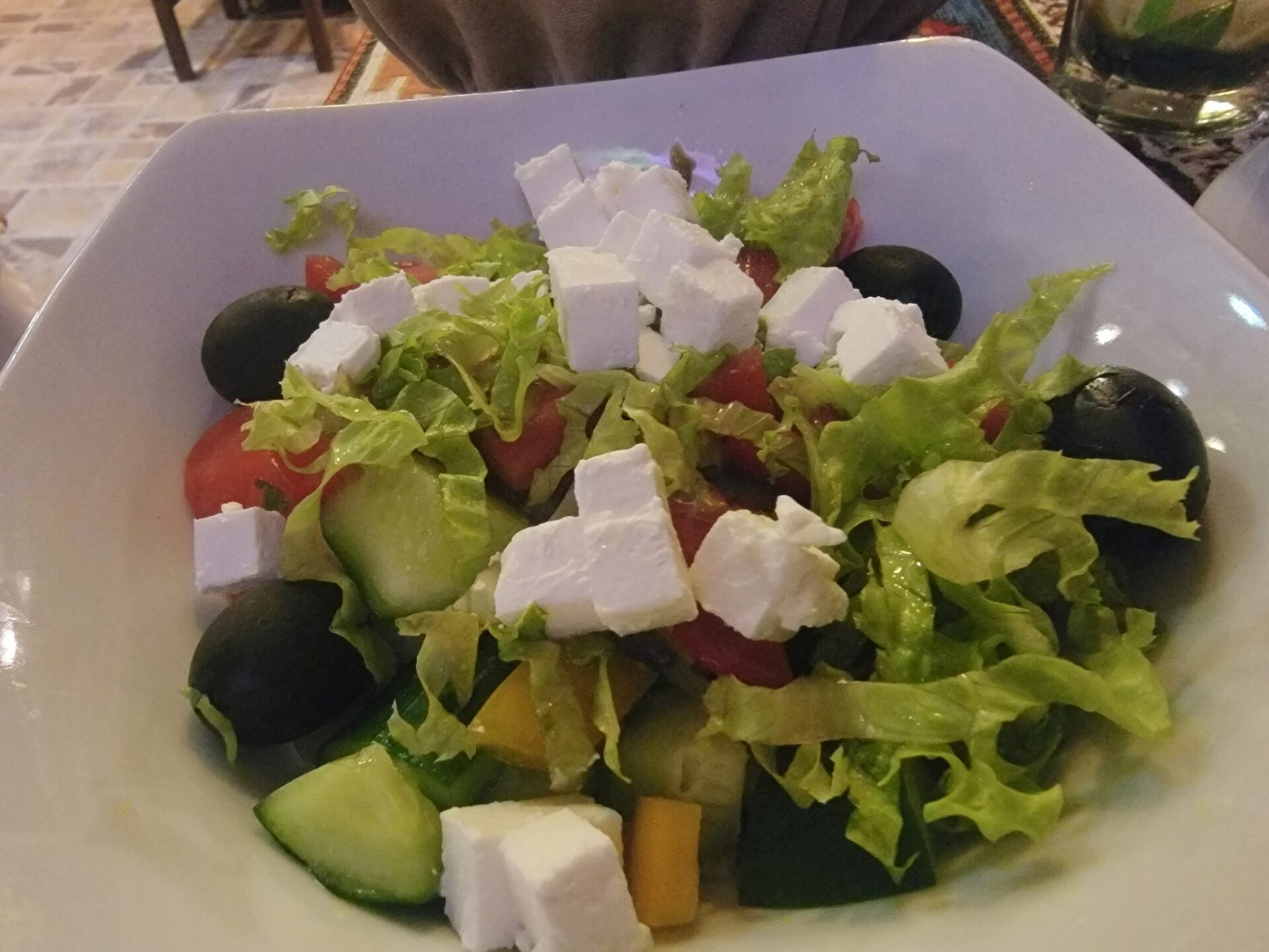 a bowl of salad with cheese and olives