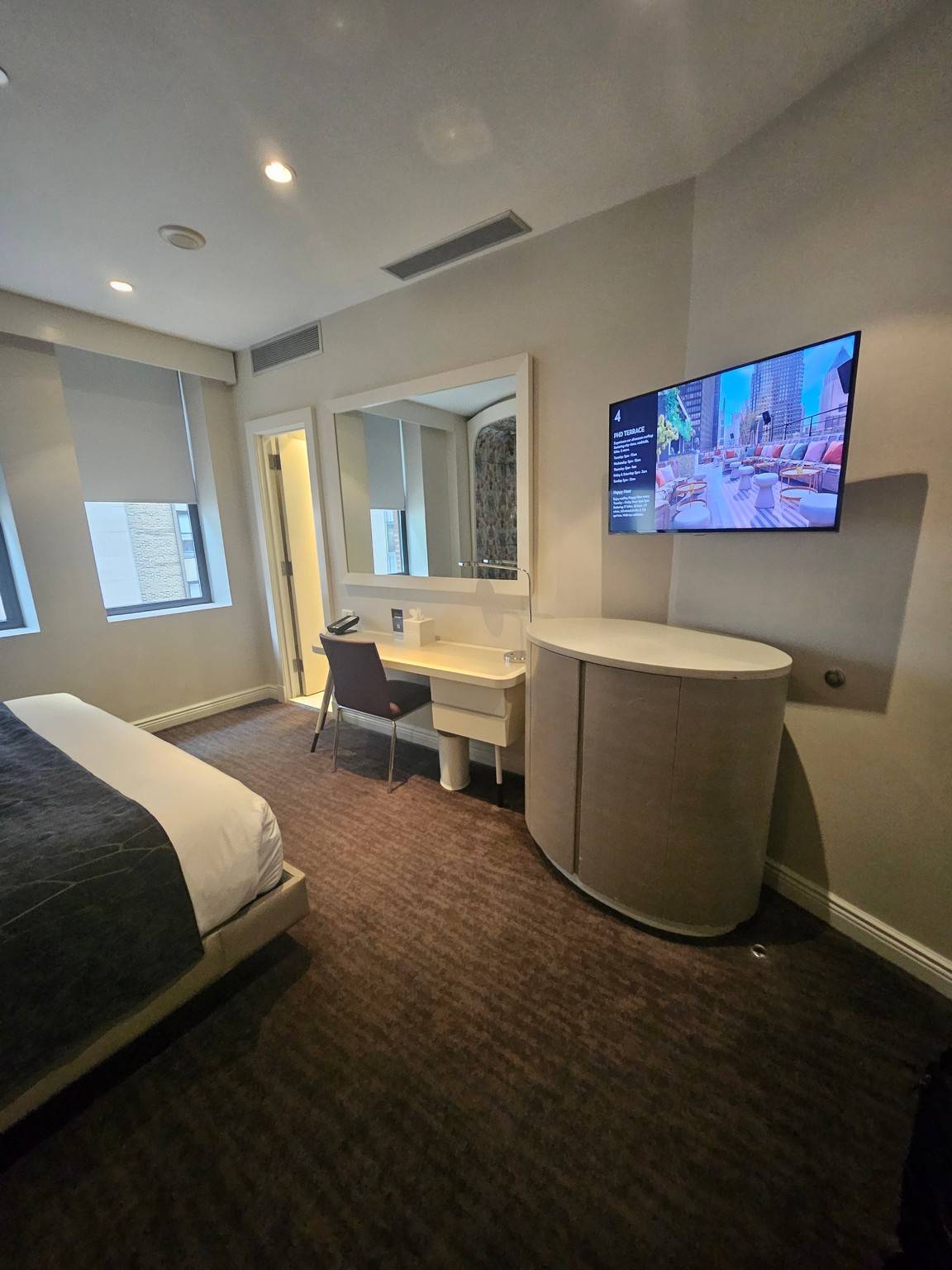 a room with a bed and a desk and a television