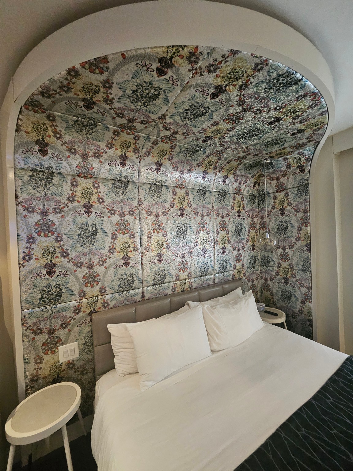 a bed with a floral wallpaper