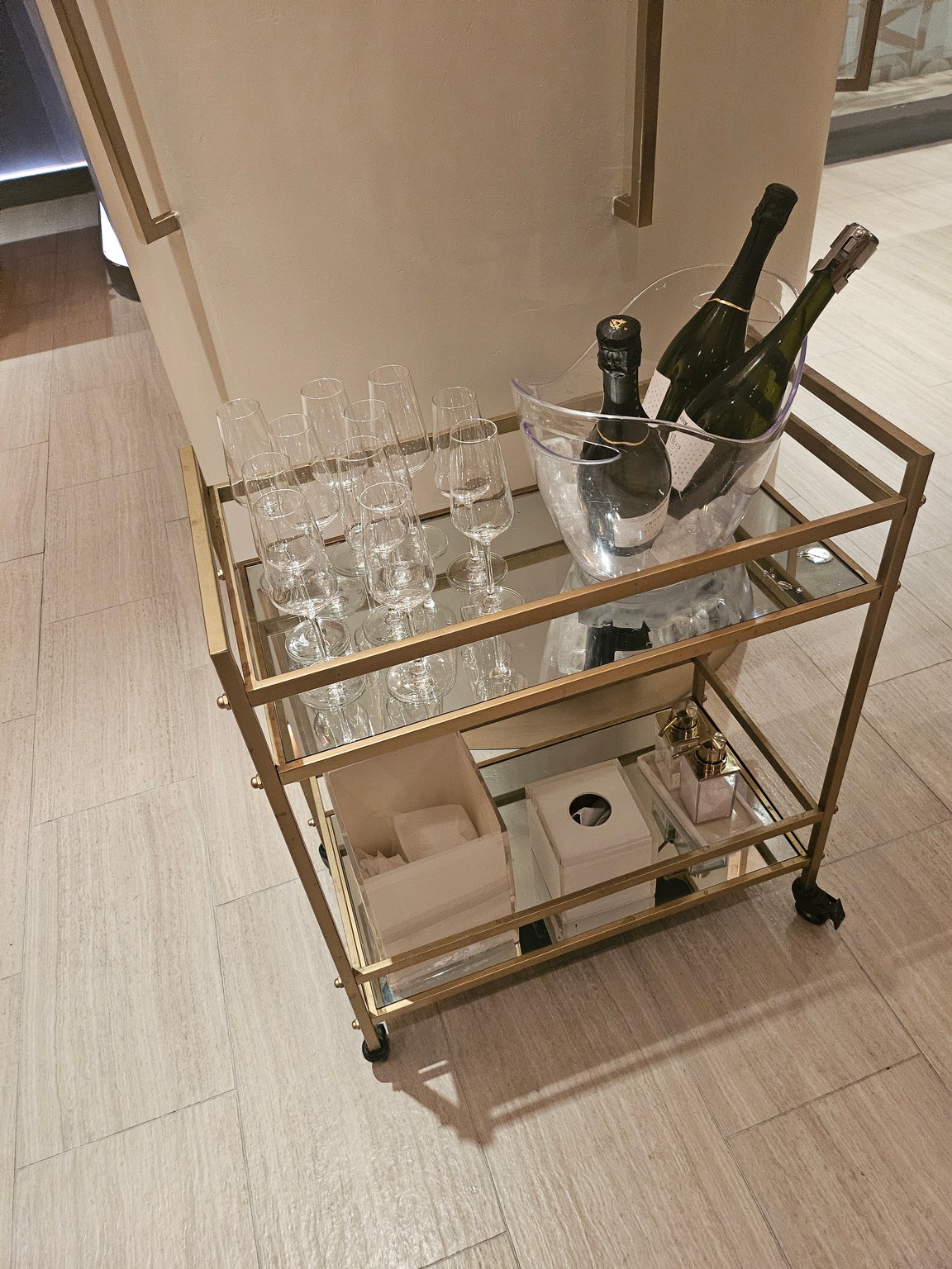 a cart with wine glasses and bottles