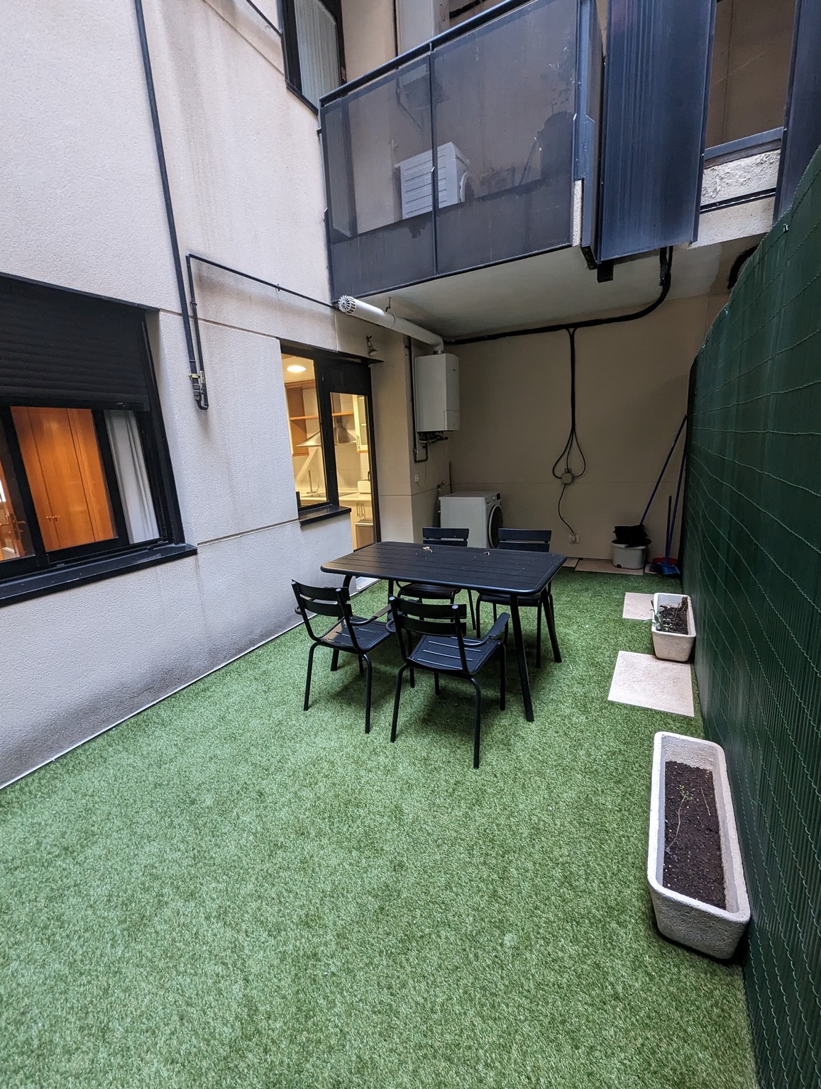 a table and chairs on a green carpeted patio