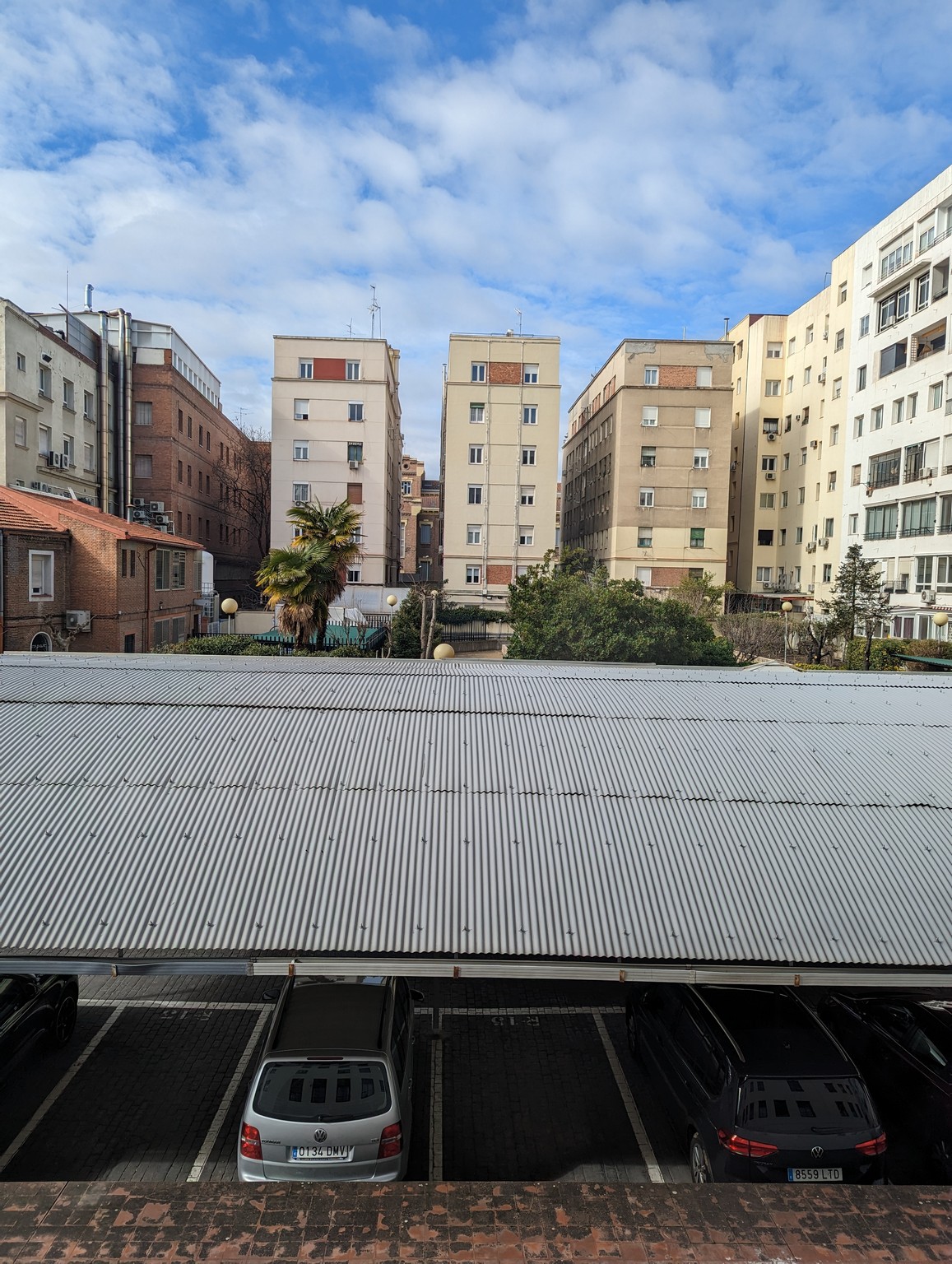 a parking lot with cars parked in front of buildings