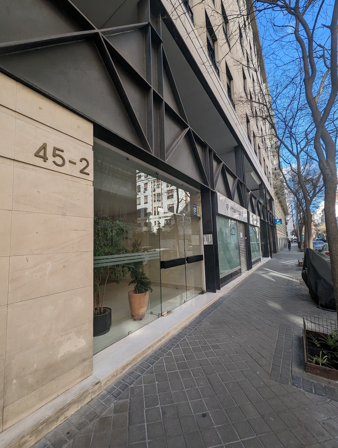 a building with glass windows and a street sign