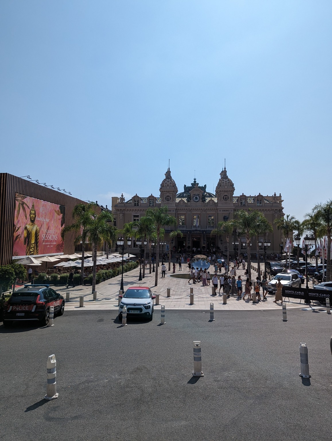 a large building with palm trees and people in front