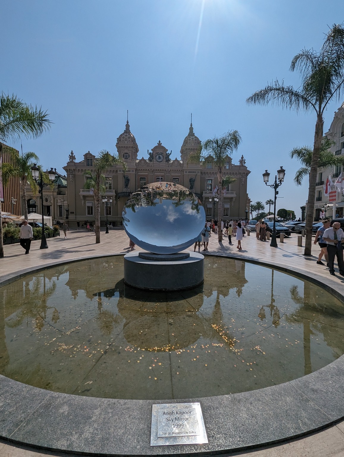 a large mirror sculpture in a fountain in front of a building