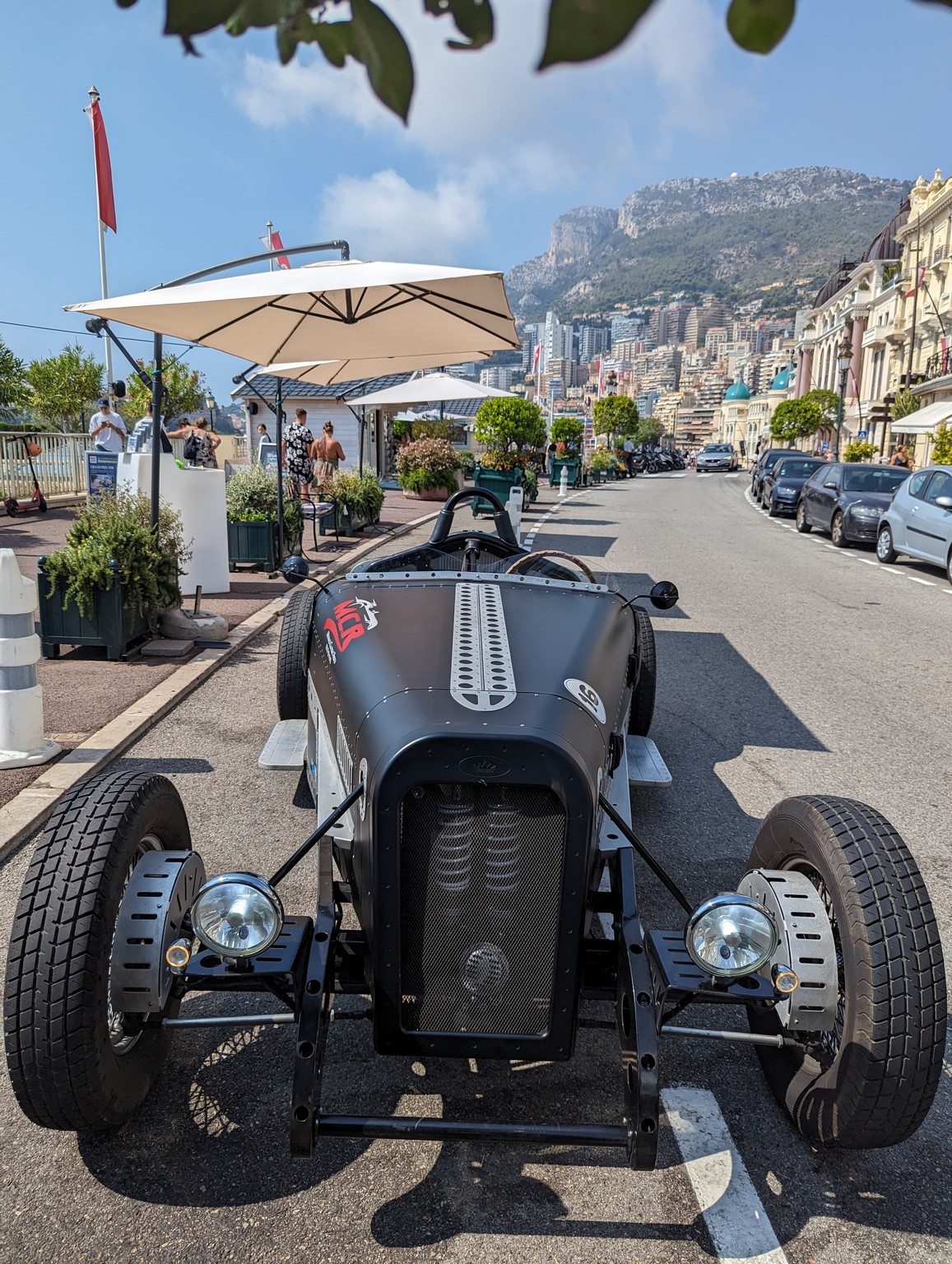 a black car parked on a road with a city in the background