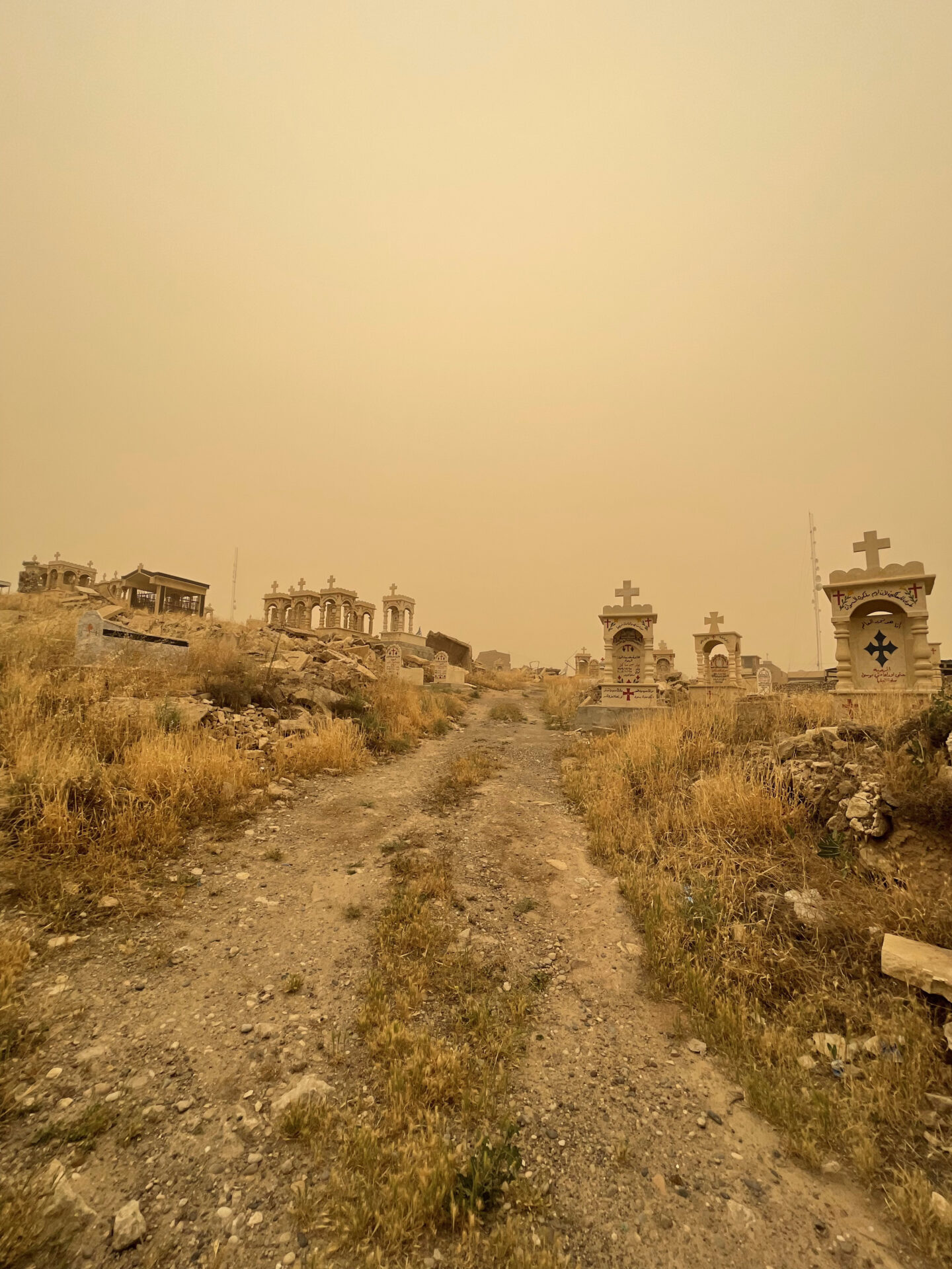 a dirt road leading to a cemetery