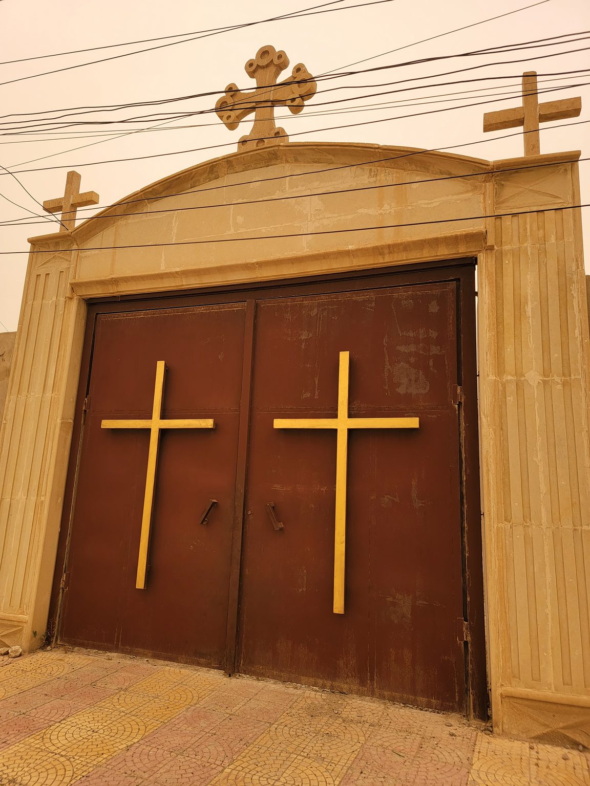 a large brown gate with crosses on top