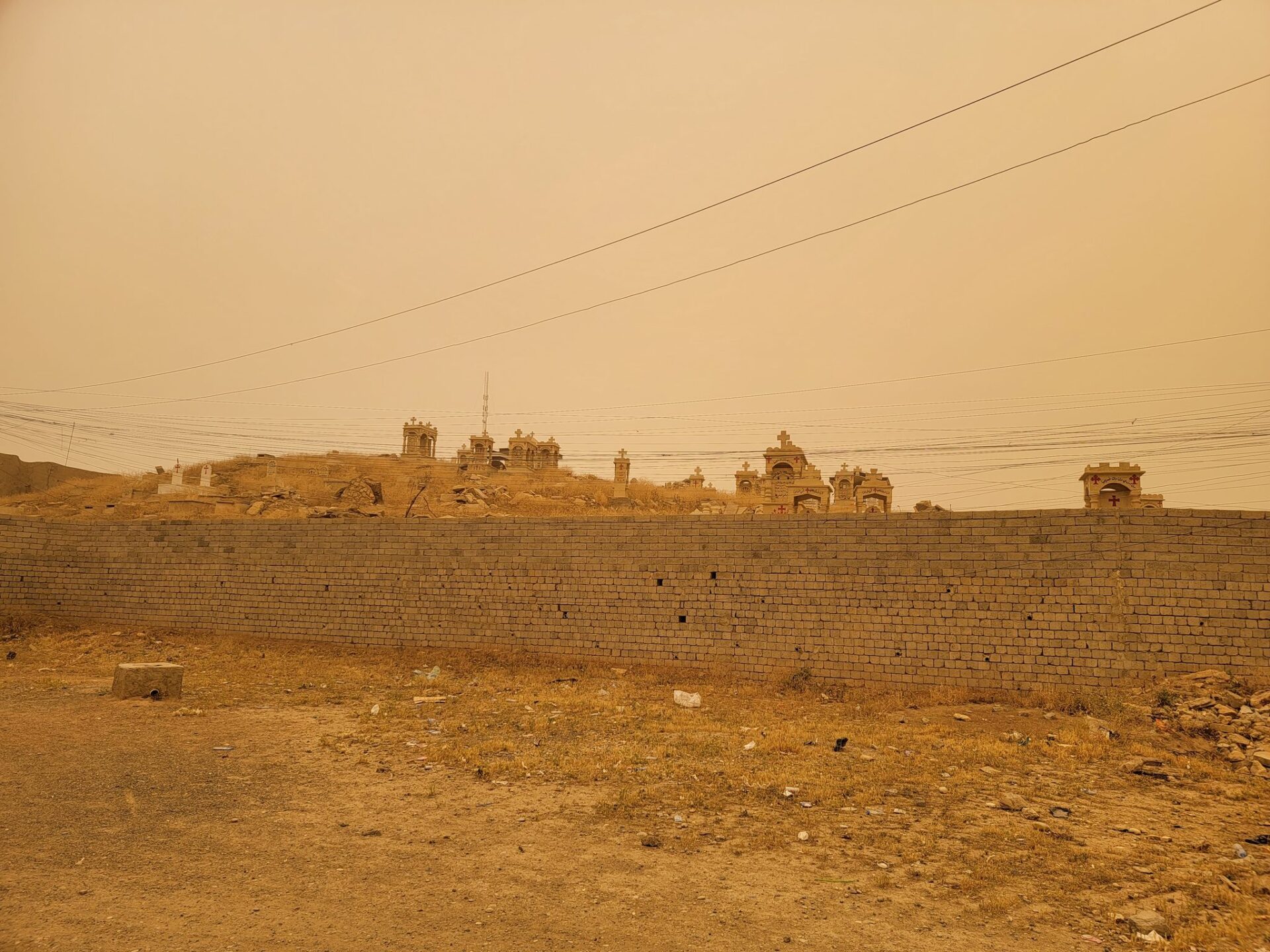 a brick wall with a dirt field behind it