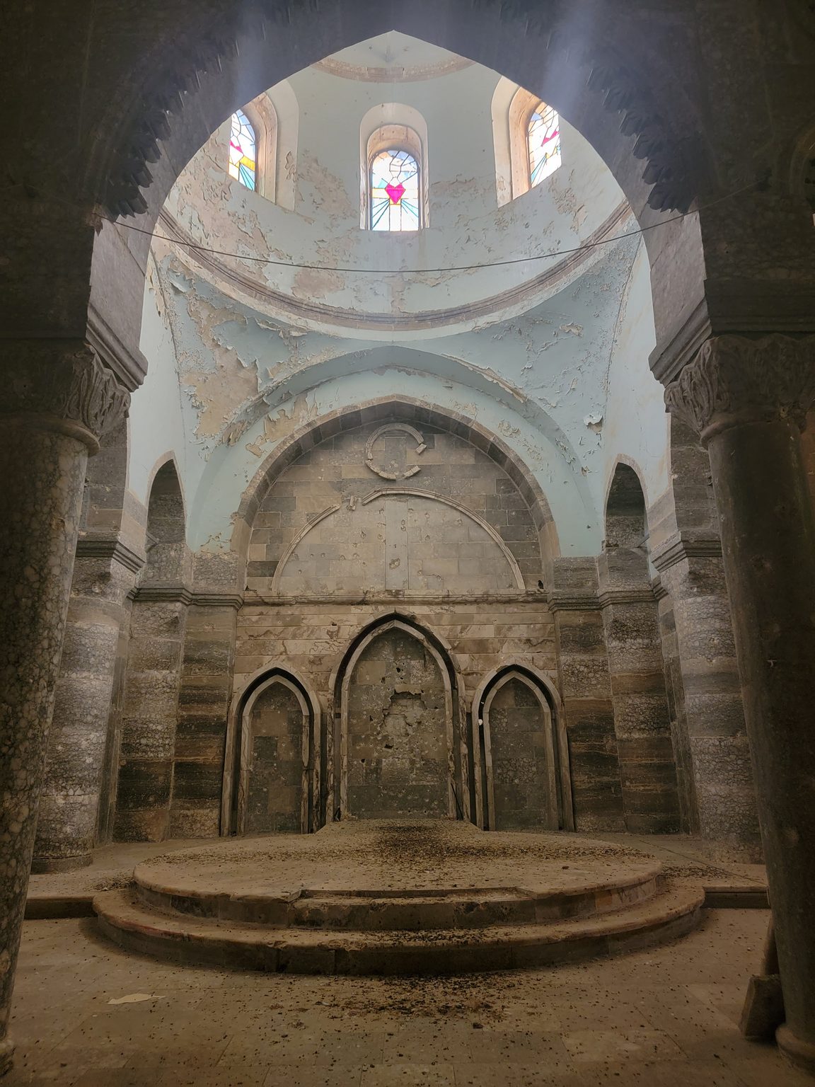 a stone building with a round staircase and stained glass windows