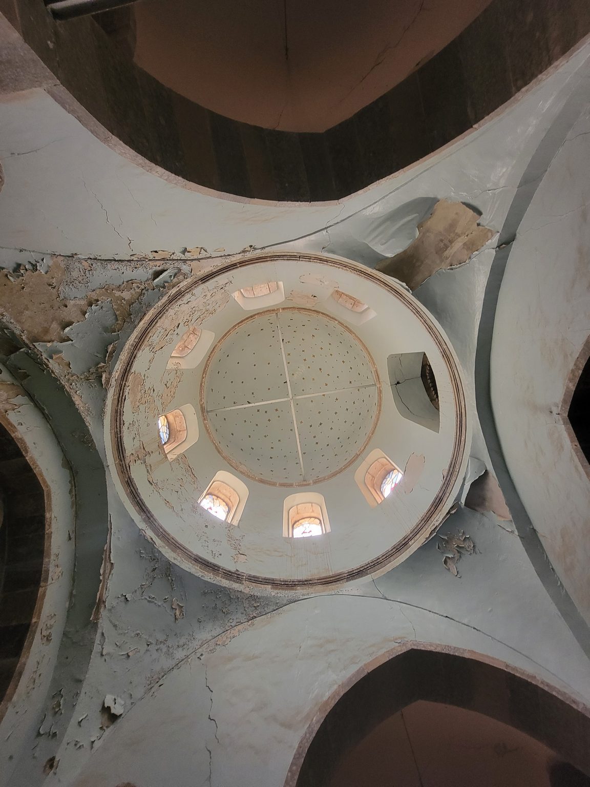 a ceiling with a circular ceiling with many windows