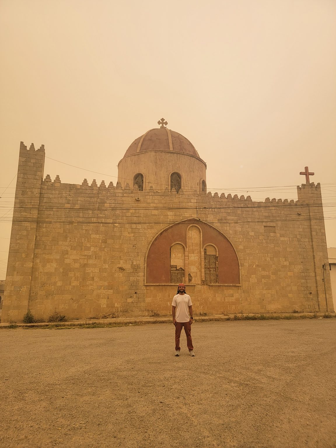 a man standing in front of a stone building