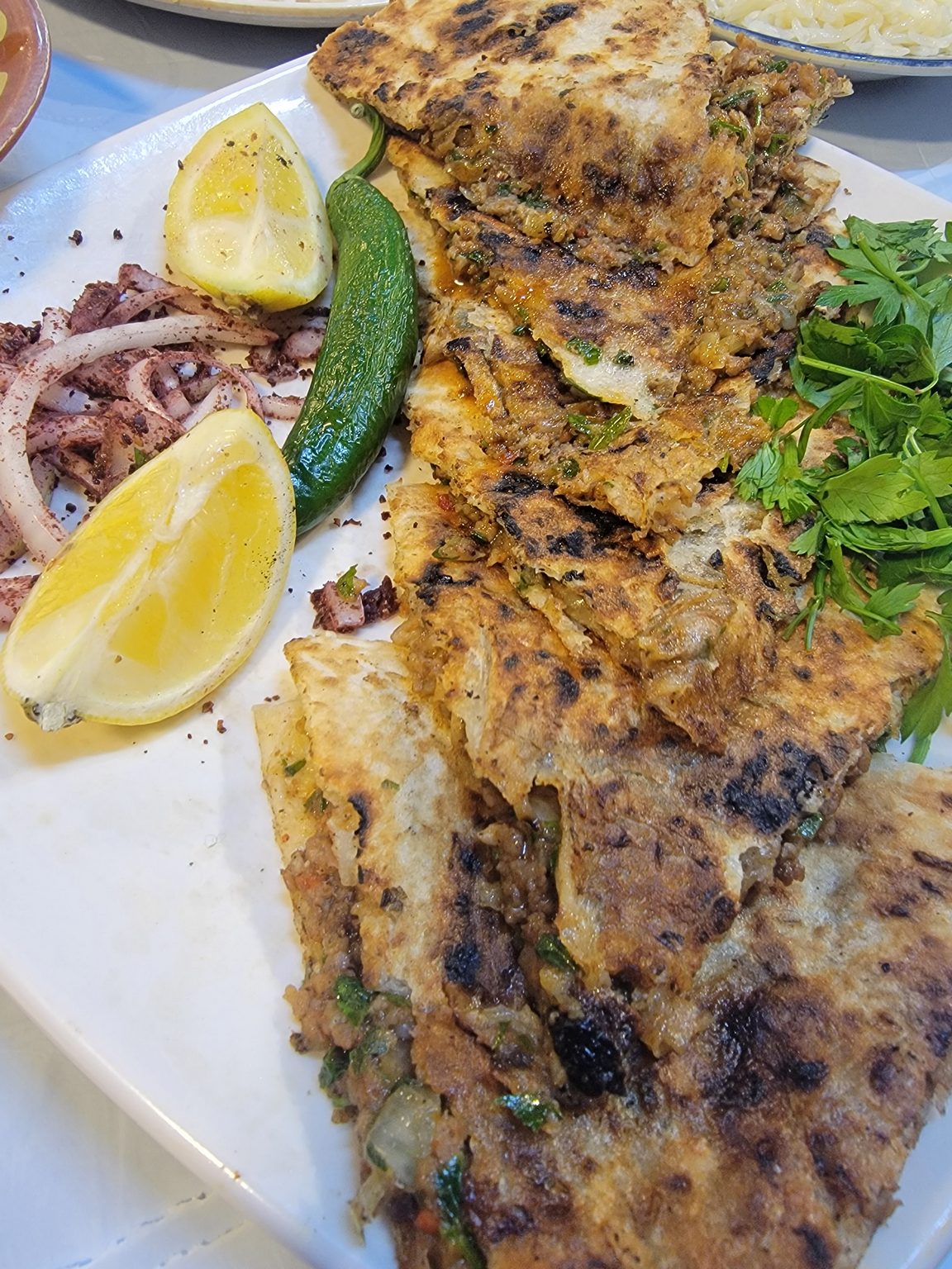 a plate of food with lemons and a pickle