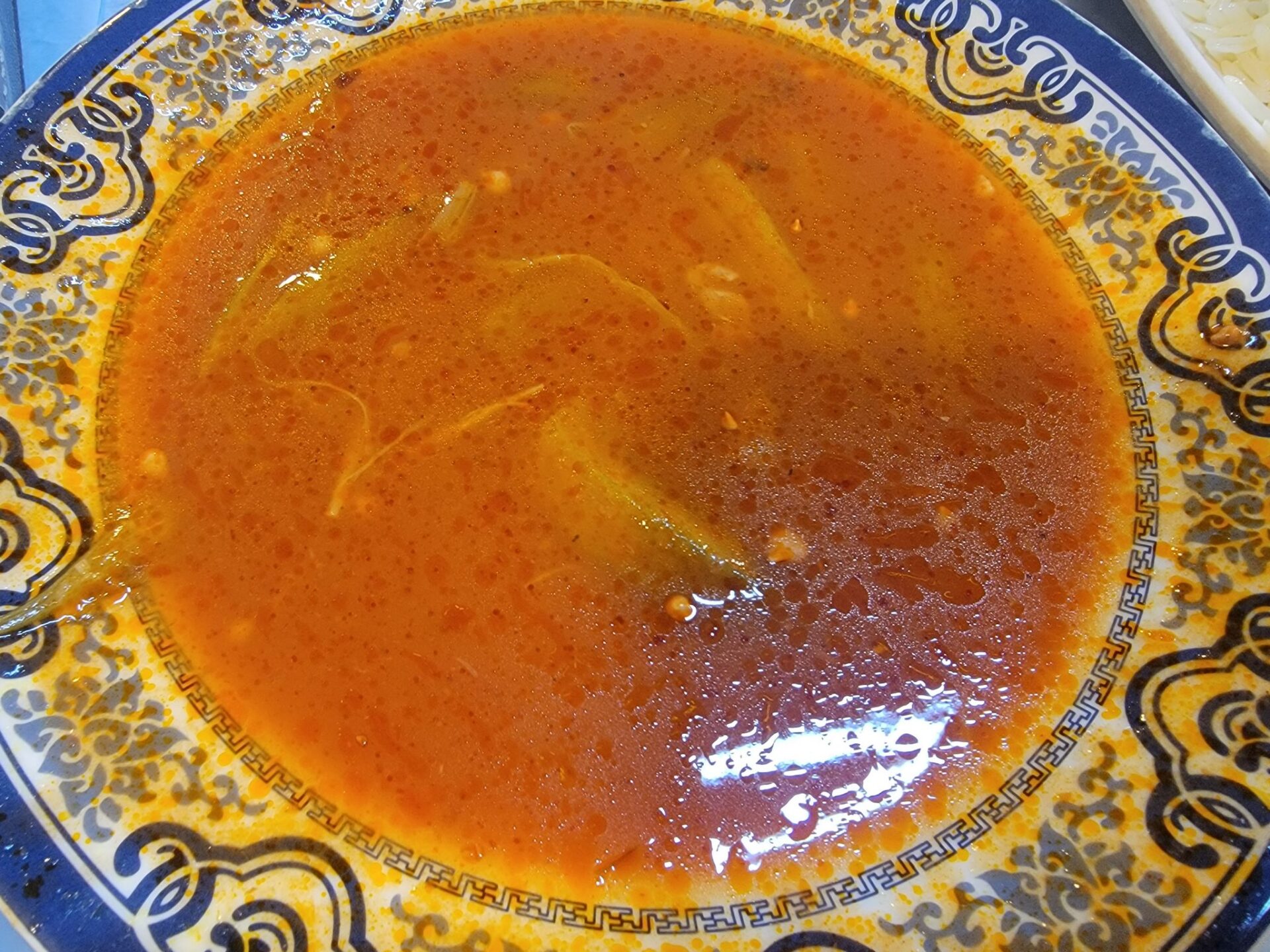 a bowl of soup with a blue and white design